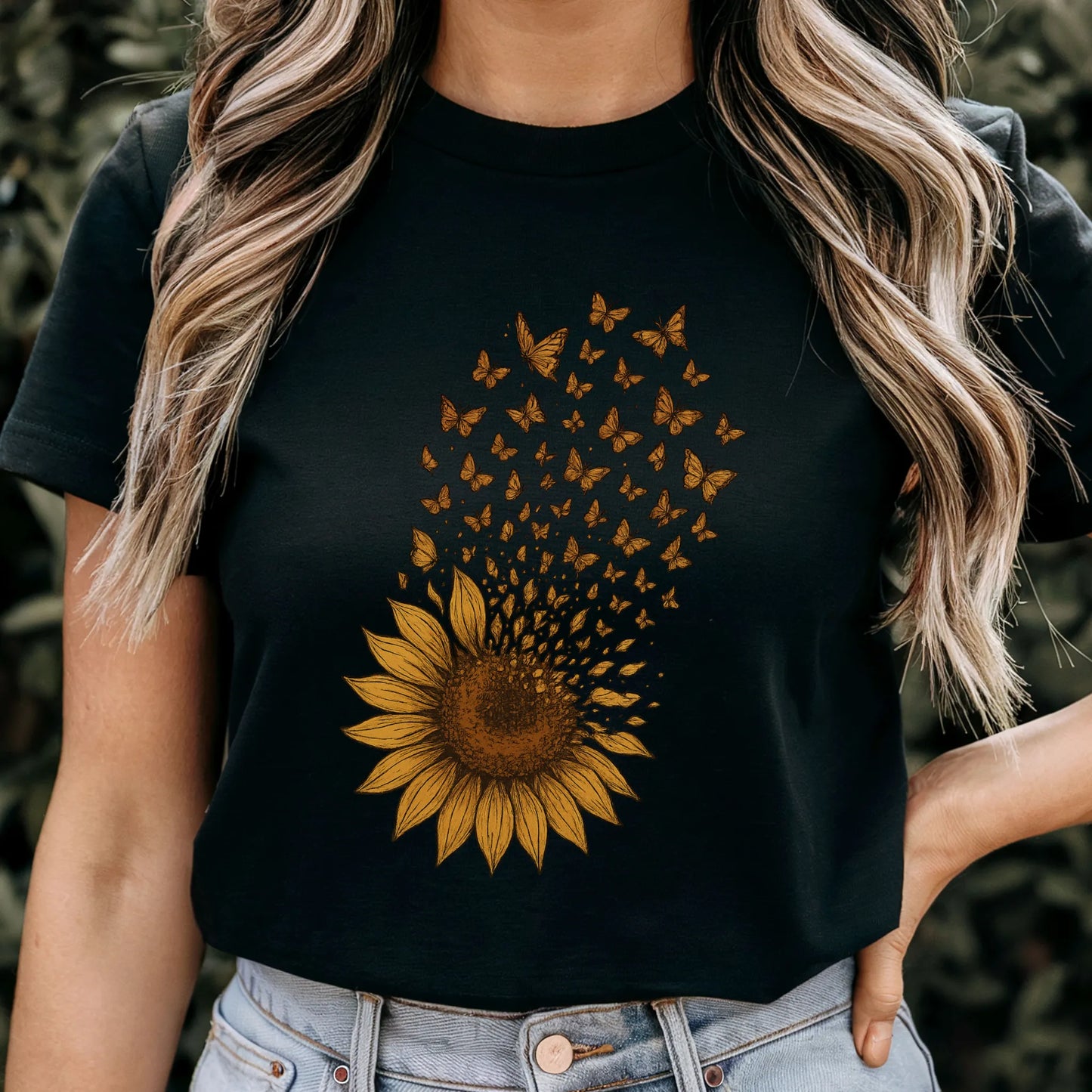Black t-shirt featuring a bold sunflower design where golden petals break apart into butterflies in flight
