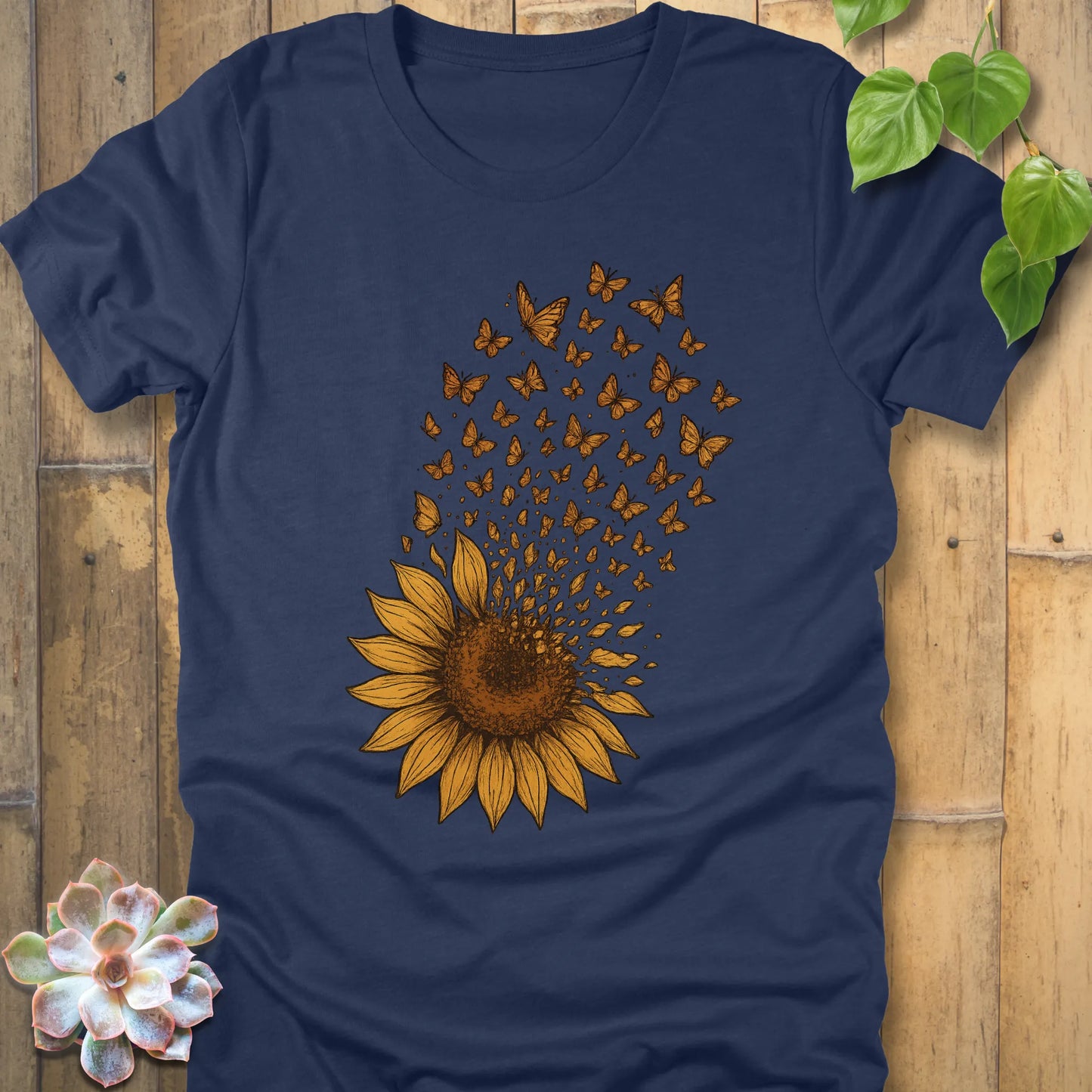 Heather Navy t-shirt with a large sunflower graphic, its petals transforming into butterflies flying upward