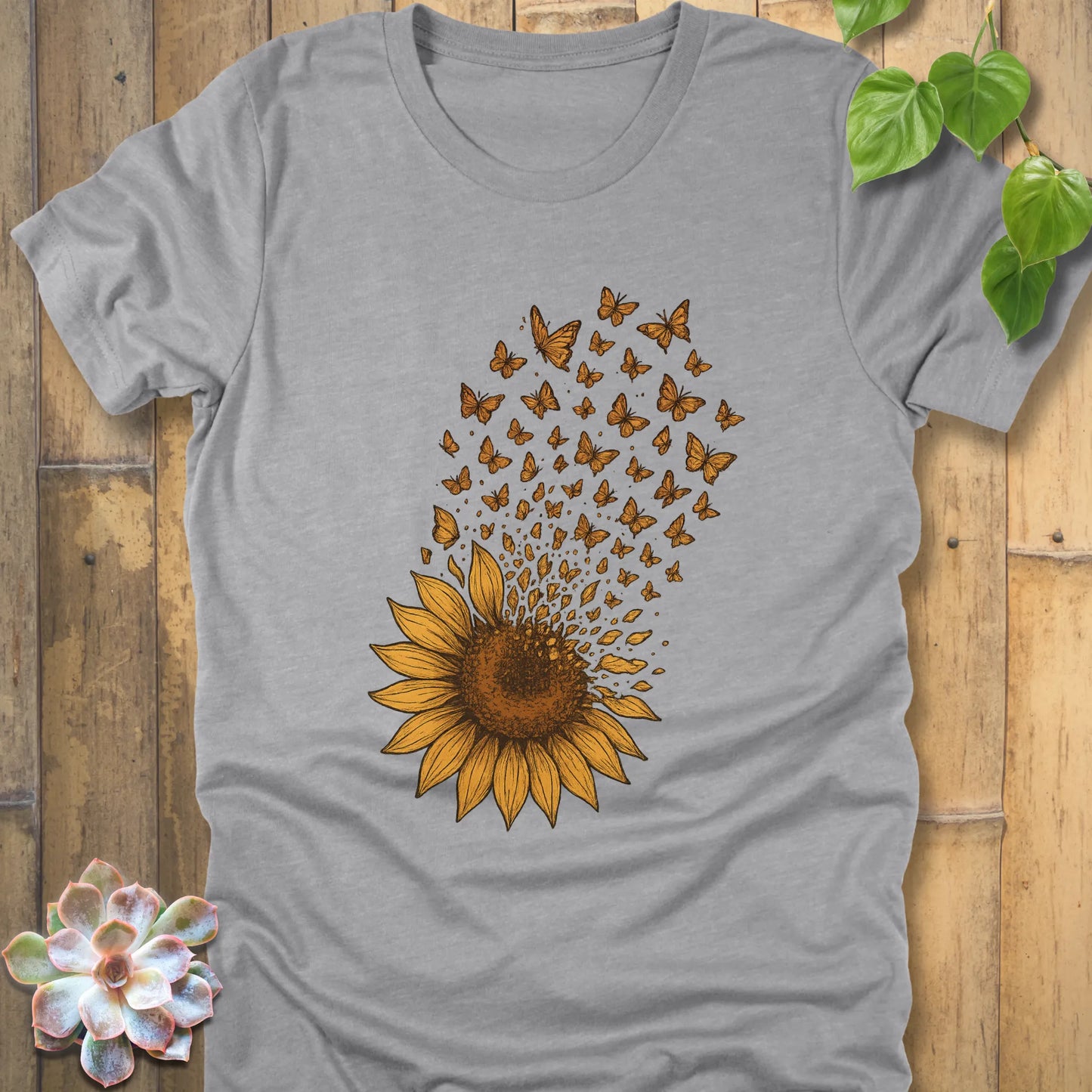 Athletic Heather t-shirt featuring a striking sunflower graphic, its petals transforming into butterflies