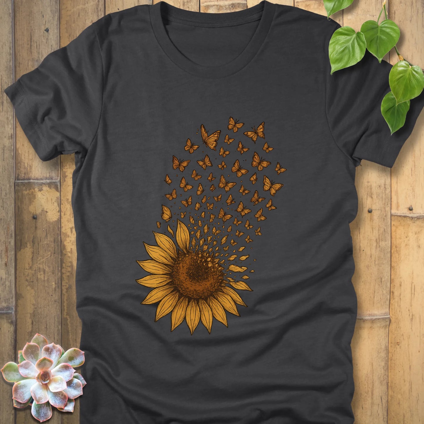 Dark Grey Heather t-shirt with a sunflower illustration, petals dissolving into butterflies rising above