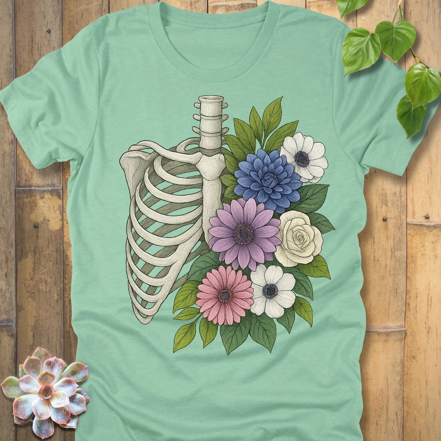 Floral Bones T-shirt in Heather Mint – skeleton ribcage with flowers graphic, premium quality Bella+Canvas tee.