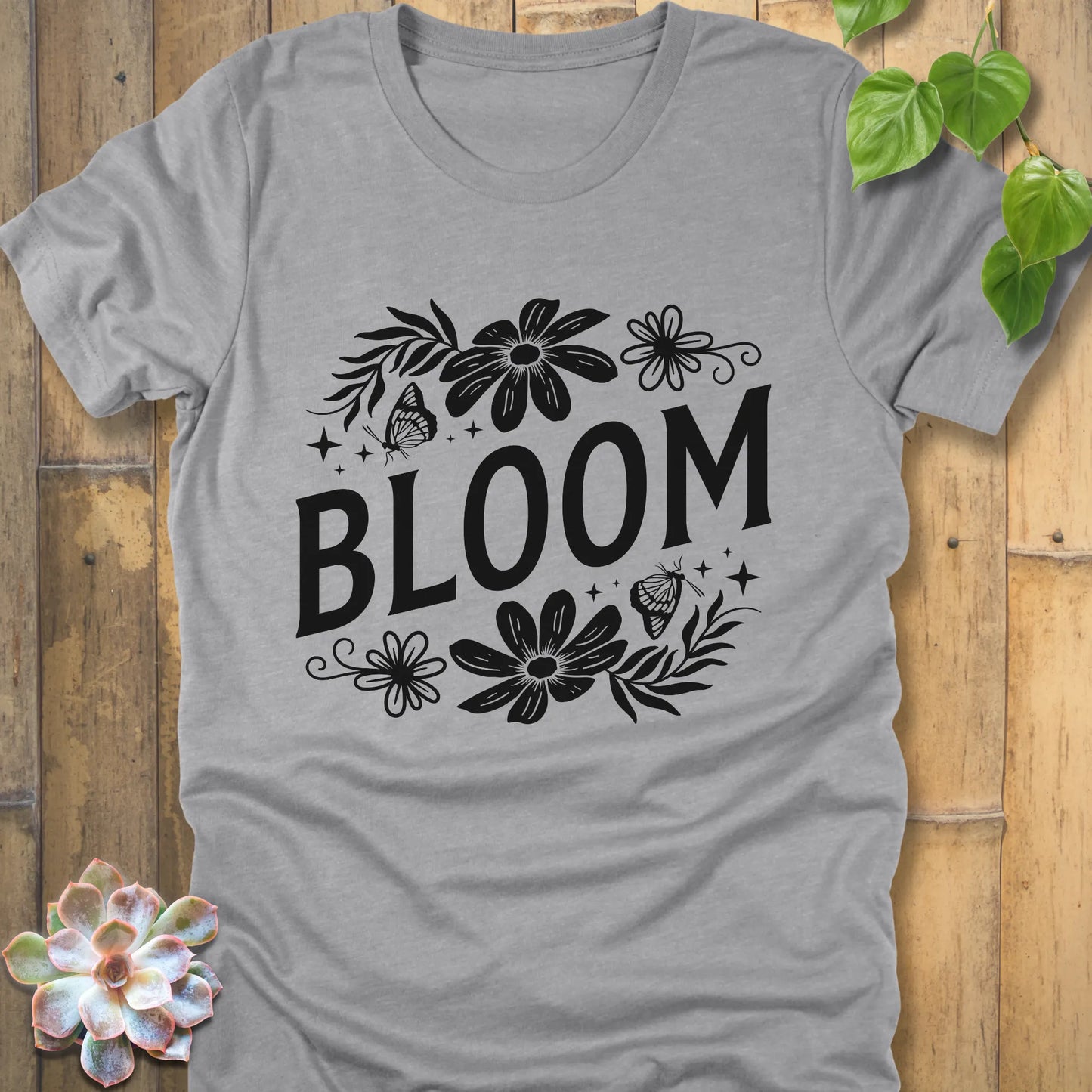 Athletic grey t-shirt featuring the design " Bloom " printed in bold black letters with flowers