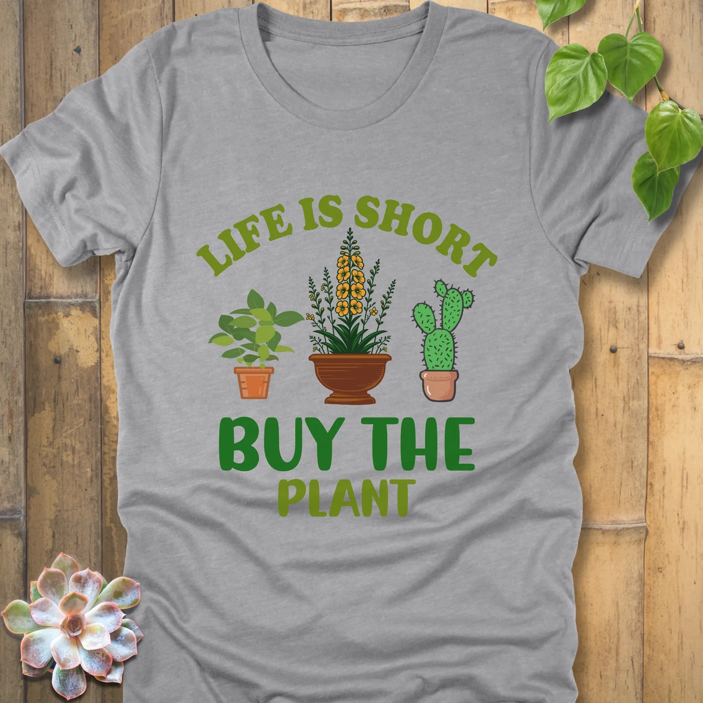 Athletic grey t-shirt featuring the design Life is short, buy the plant printed in green text with plant illustration