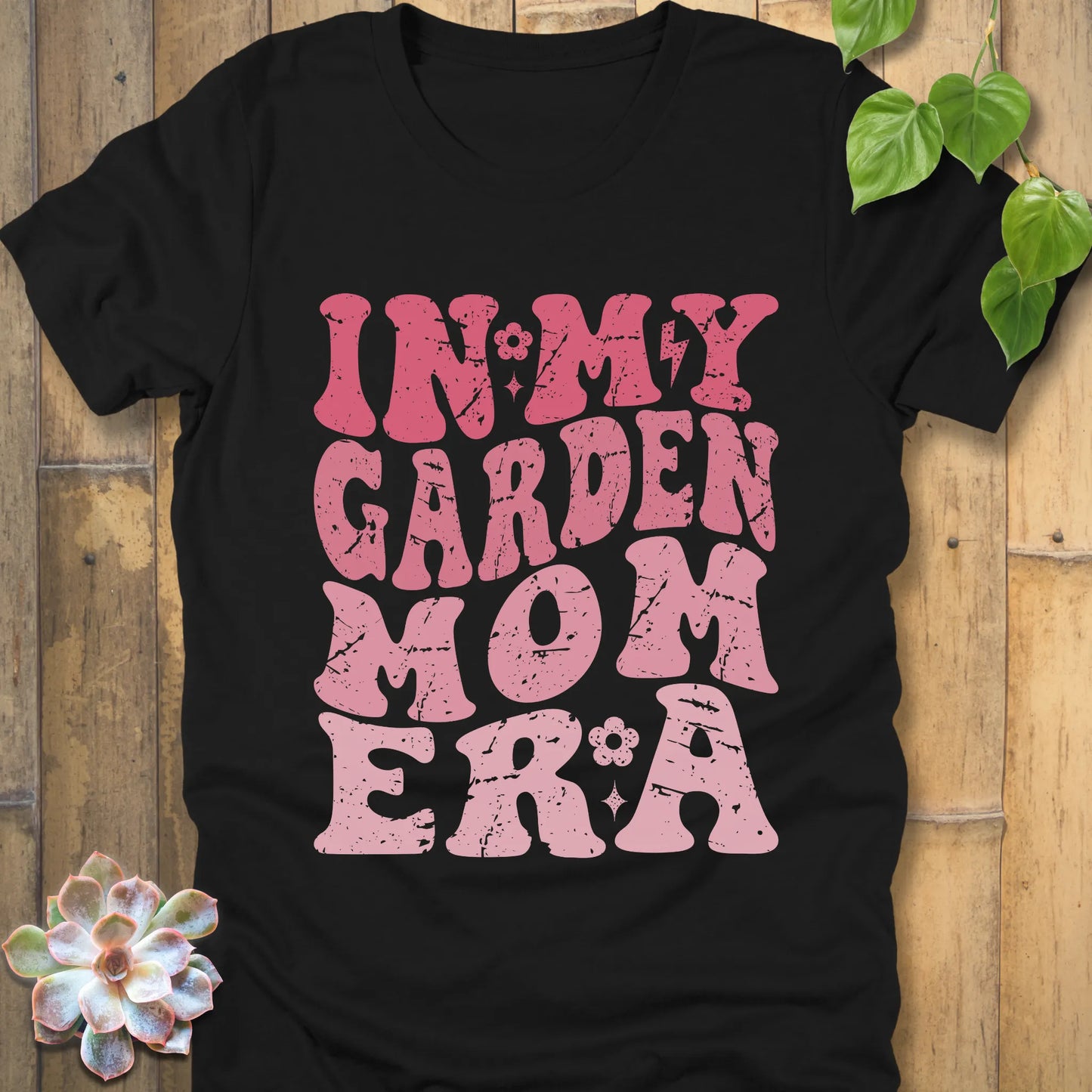 Black t-shirt featuring the design In My Garden Mom Era printed in bold pink letters, chic outdoor gardening wear.