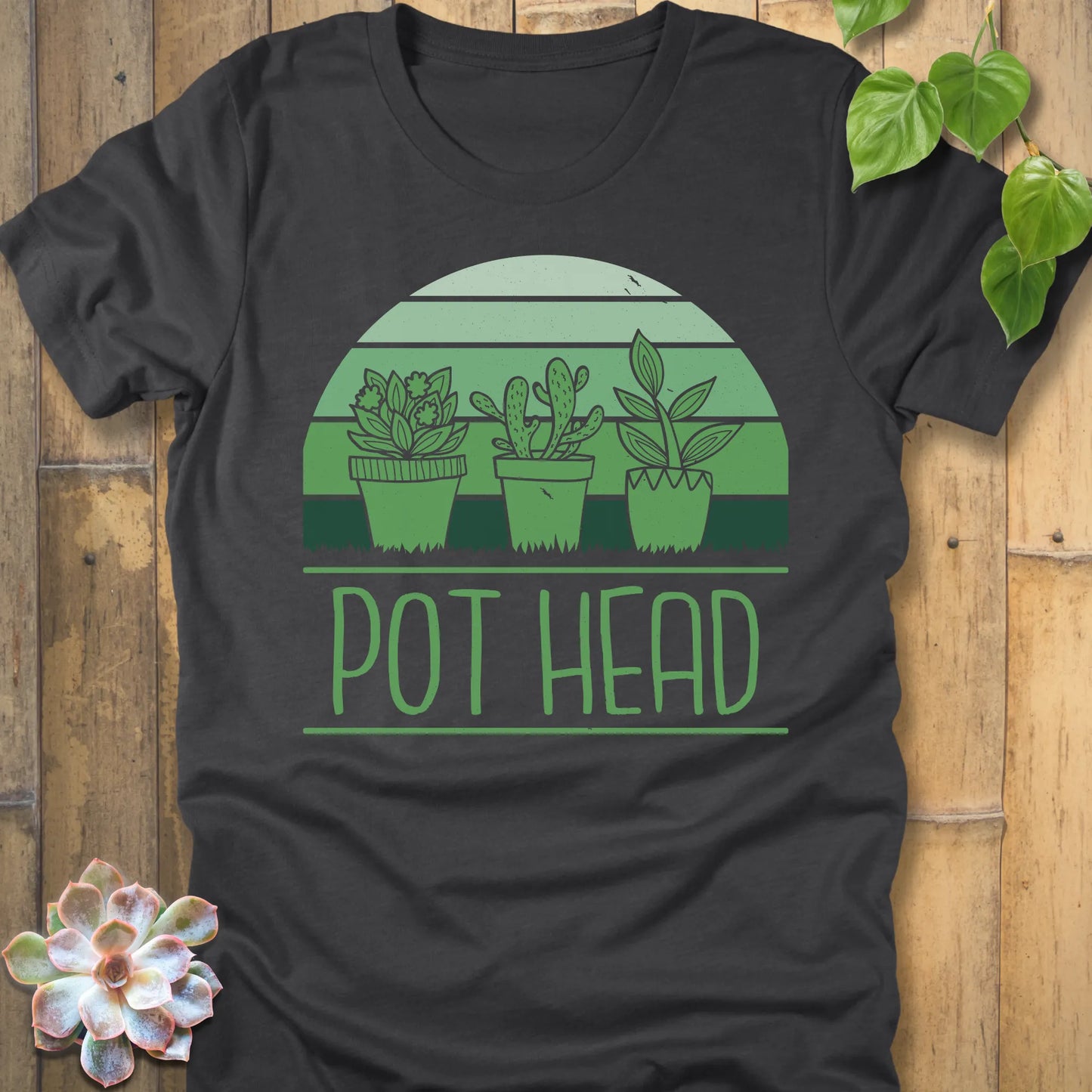 Dark Grey Heather t-shirt featuring the design Pot Head printed in bold letters and 3 different plant in the pots, funny plant lover shirt.