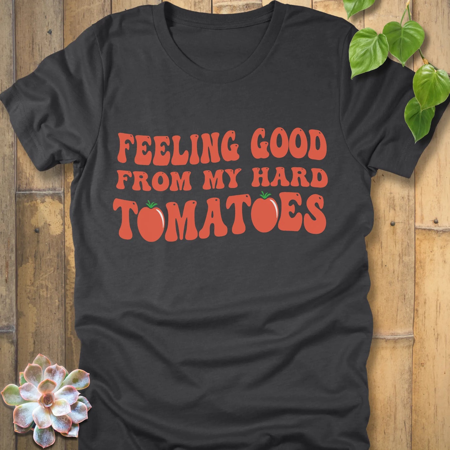 Dark grey heather t-shirt featuring the design "Feeling Good from my hard tomatoes" printed in bold orange letters