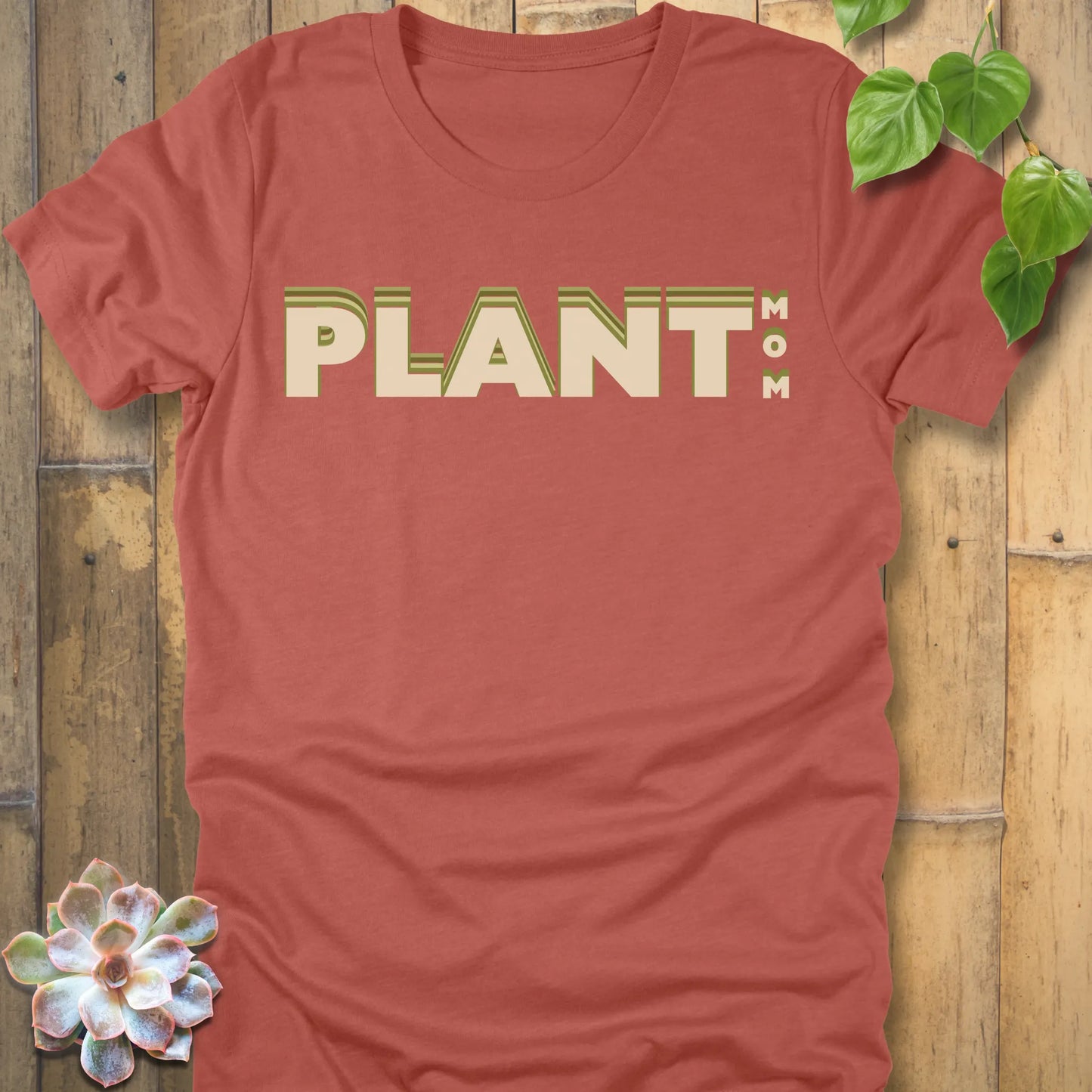 Heather Clay t-shirt featuring the design Plant Mom printed in bold green letters
