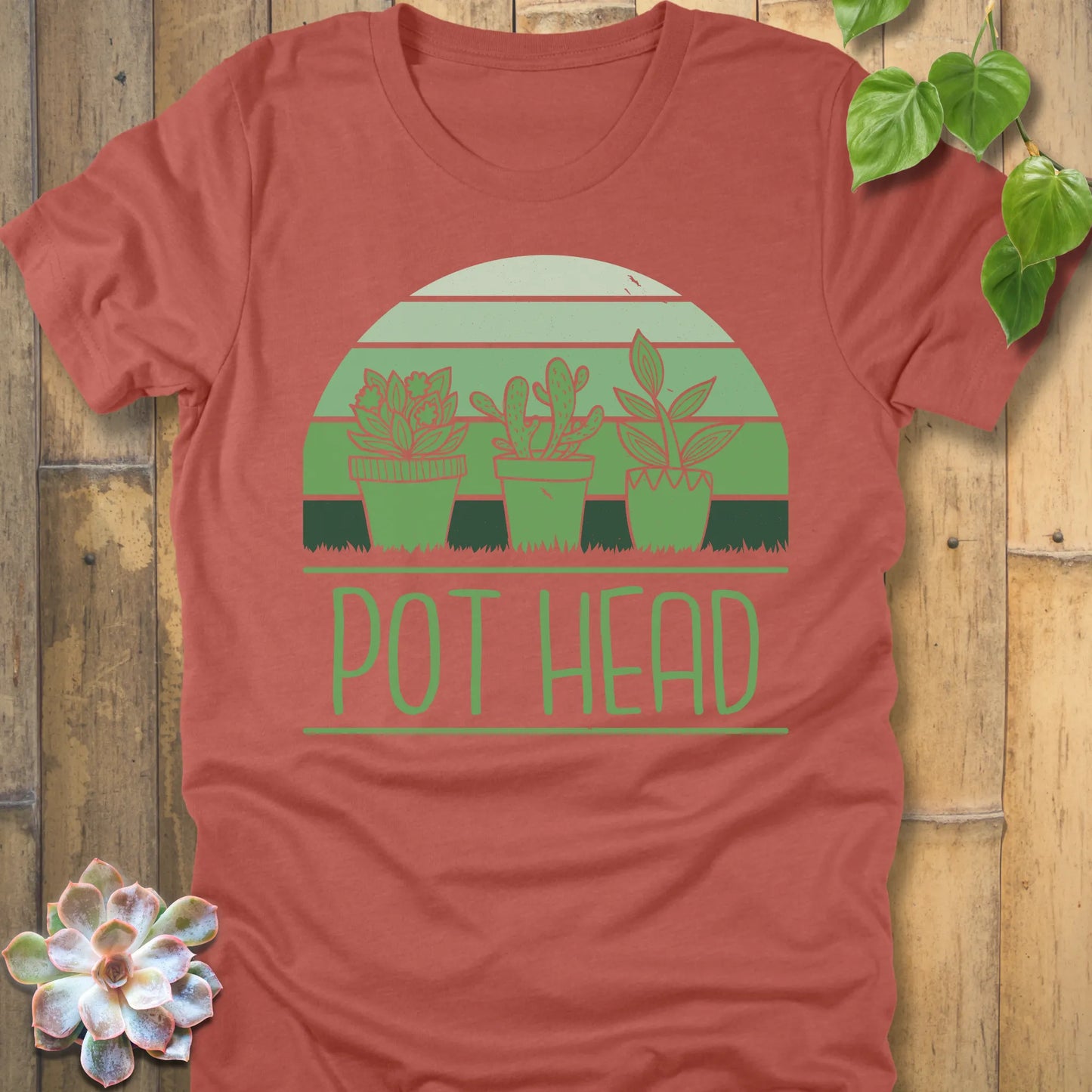 Heather Clay t-shirt featuring the design Pot Head printed in bold letters and 3 different plant in the pots, funny plant lover shirt.