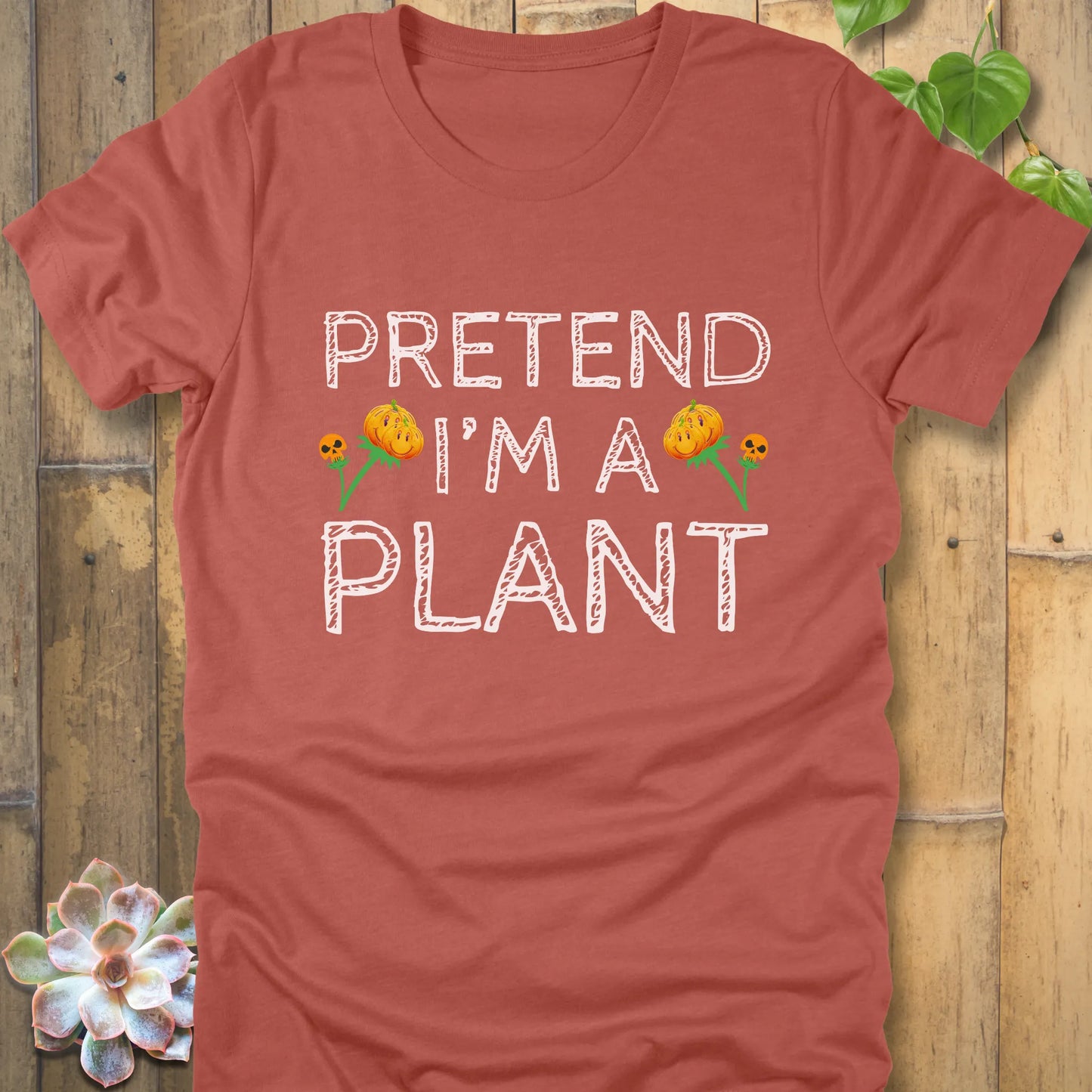 Heather Clay t-shirt featuring the design Pretend I'm A Plant printed in bold white letters with plants