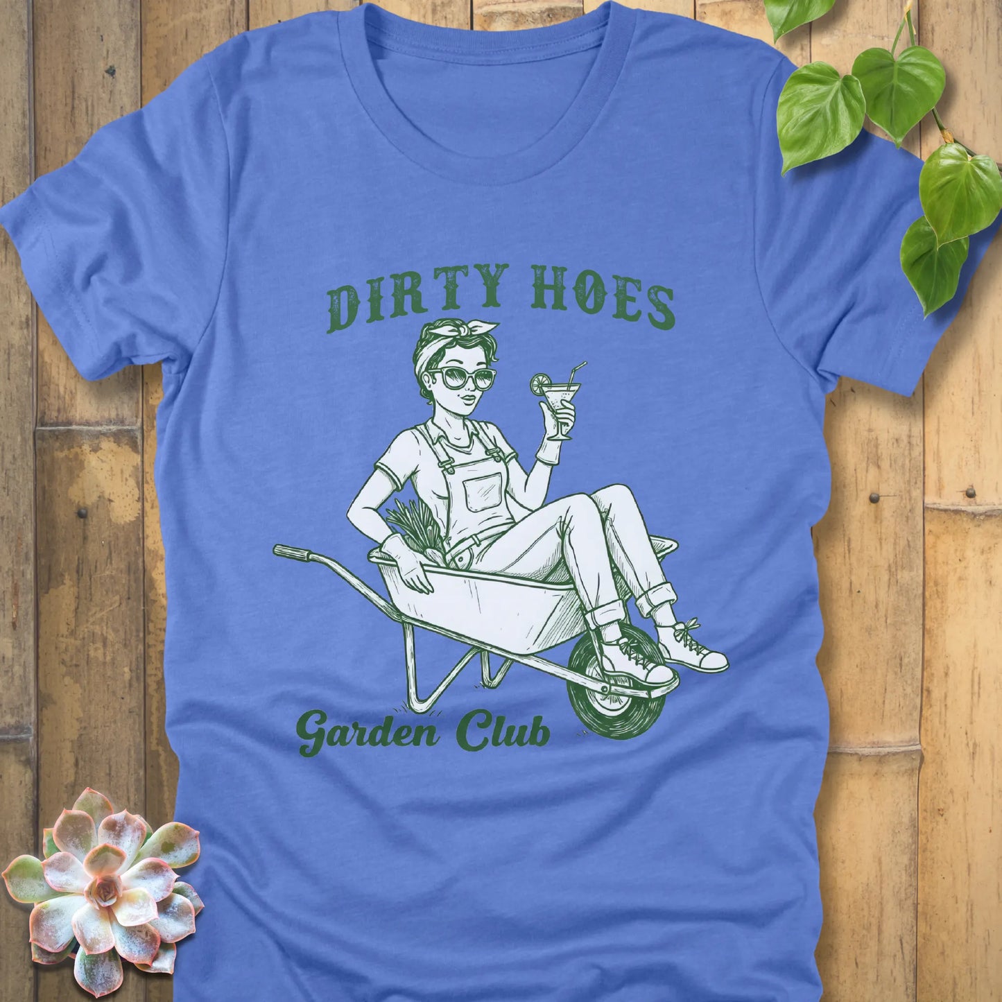 Heather Colombia Blue t-shirt featuring the design Dirty Hoes, Garden Club printed in green letters with a girl in the trolley, gardening graphic tee.