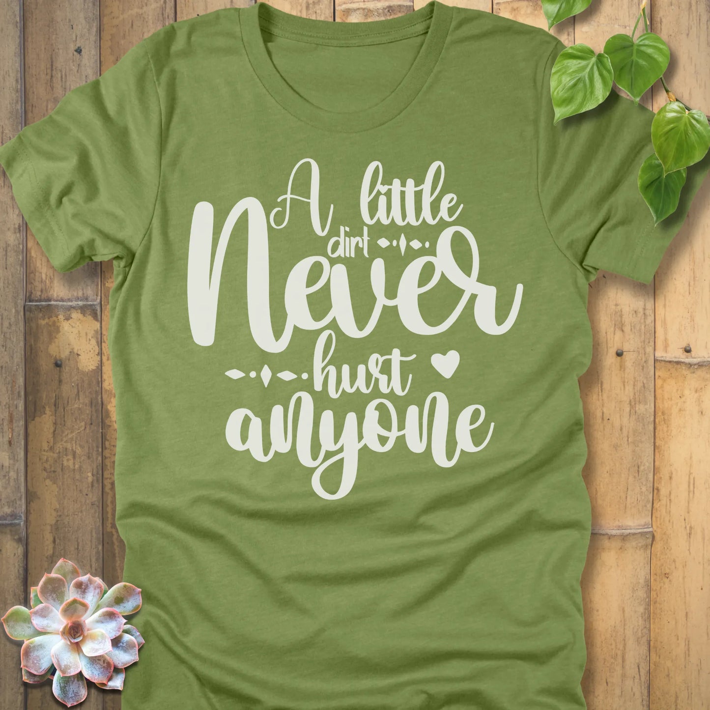 Heather Green gardening t-shirt featuring the design A Little Dirt printed in white letters