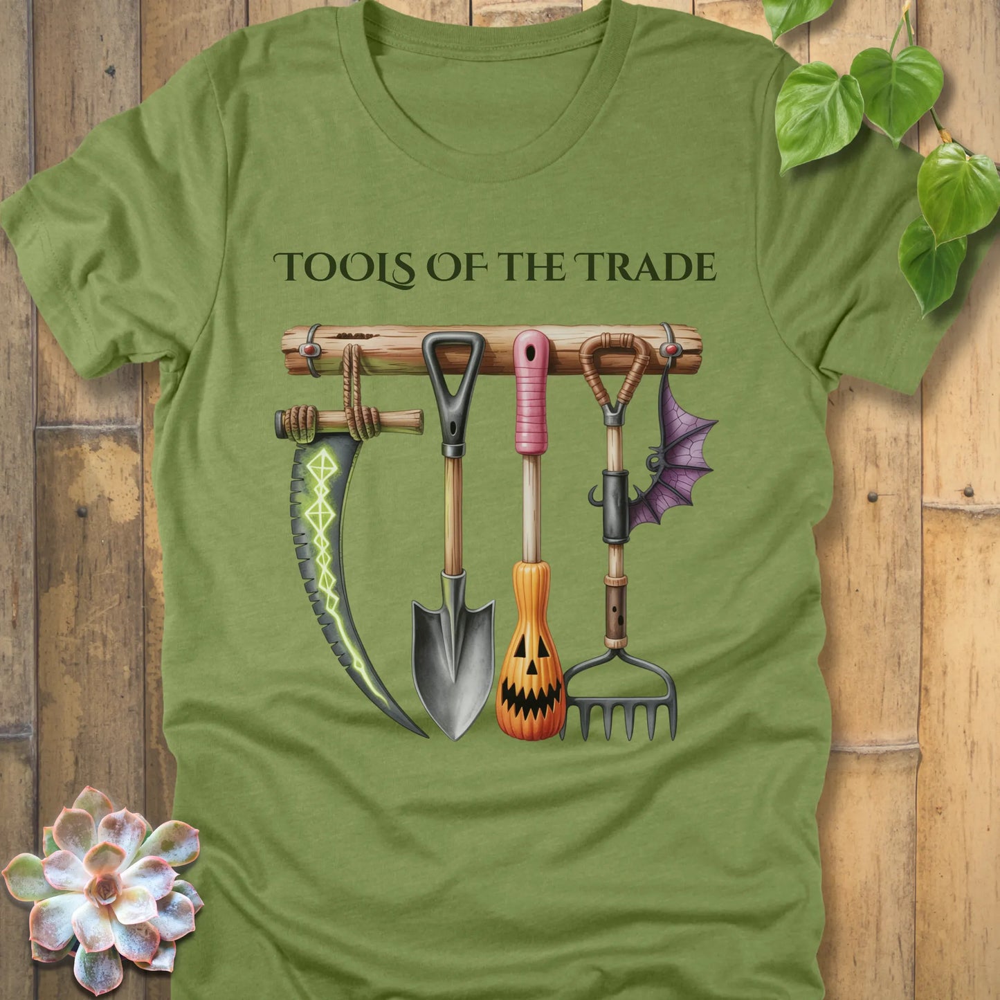 Heather Green t-shirt featuring the design Tools of the Trade printed in bold letters with a halloween tools