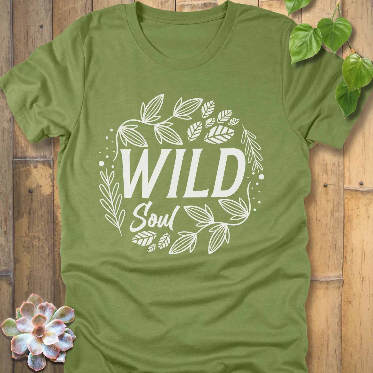 Heather Green t-shirt featuring the design Wild Soul printed in black letters with leaves