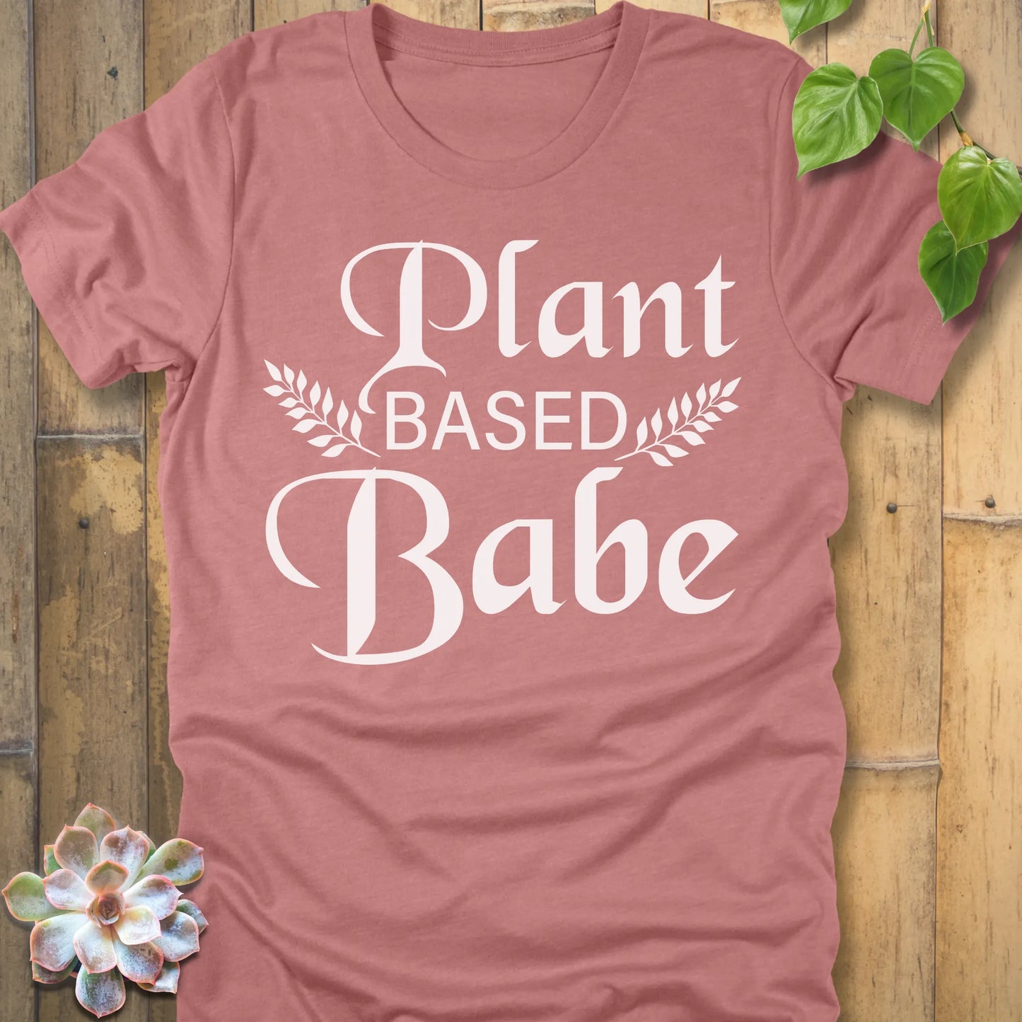 Heather Mauve t-shirt featuring the design Plant Based Babe printed in bold letters and a graphic leaves, vegan lifestyle shirt.