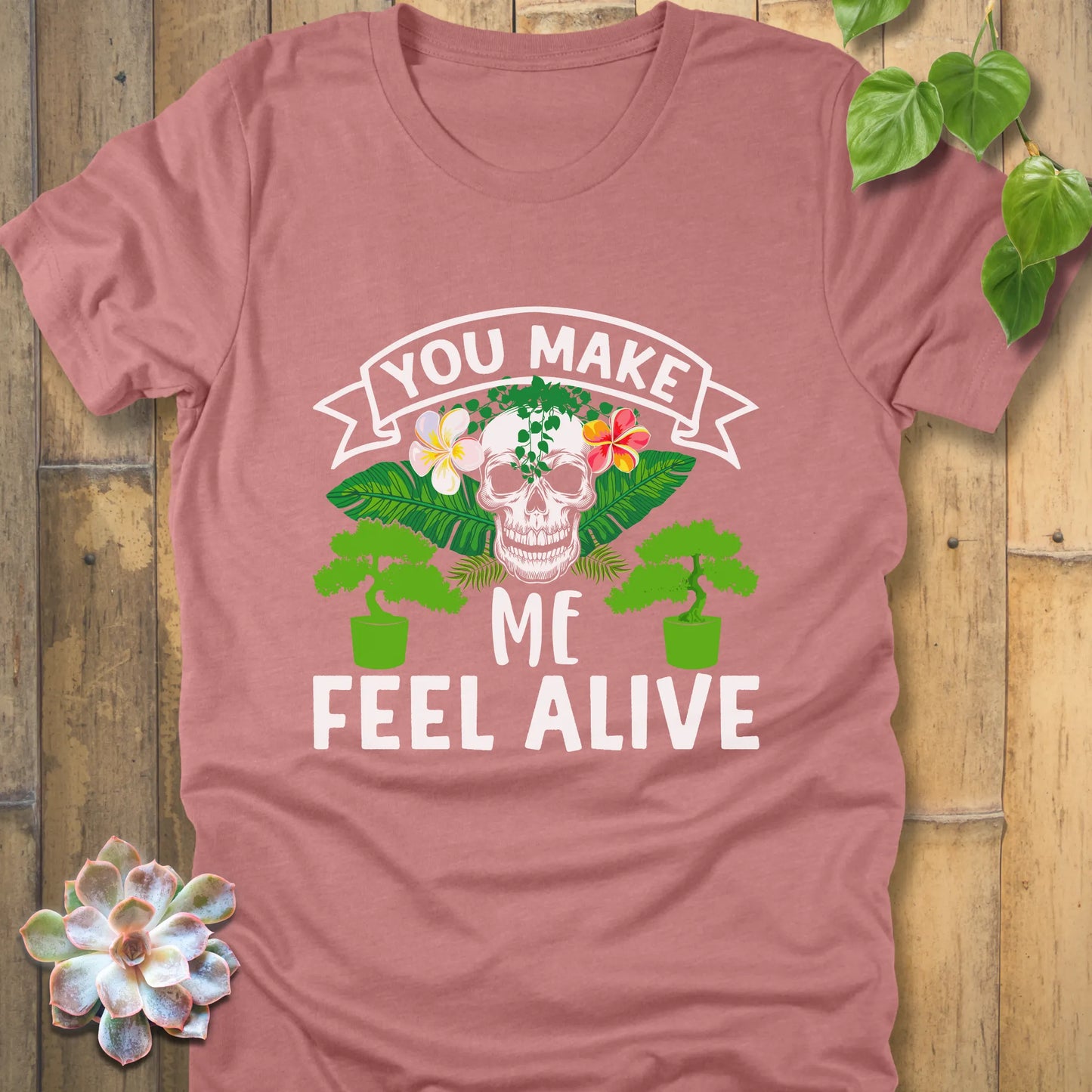 Heather Mauve t-shirt featuring the design You Make Me Feel Alive printed in bold white letters with skull and plants