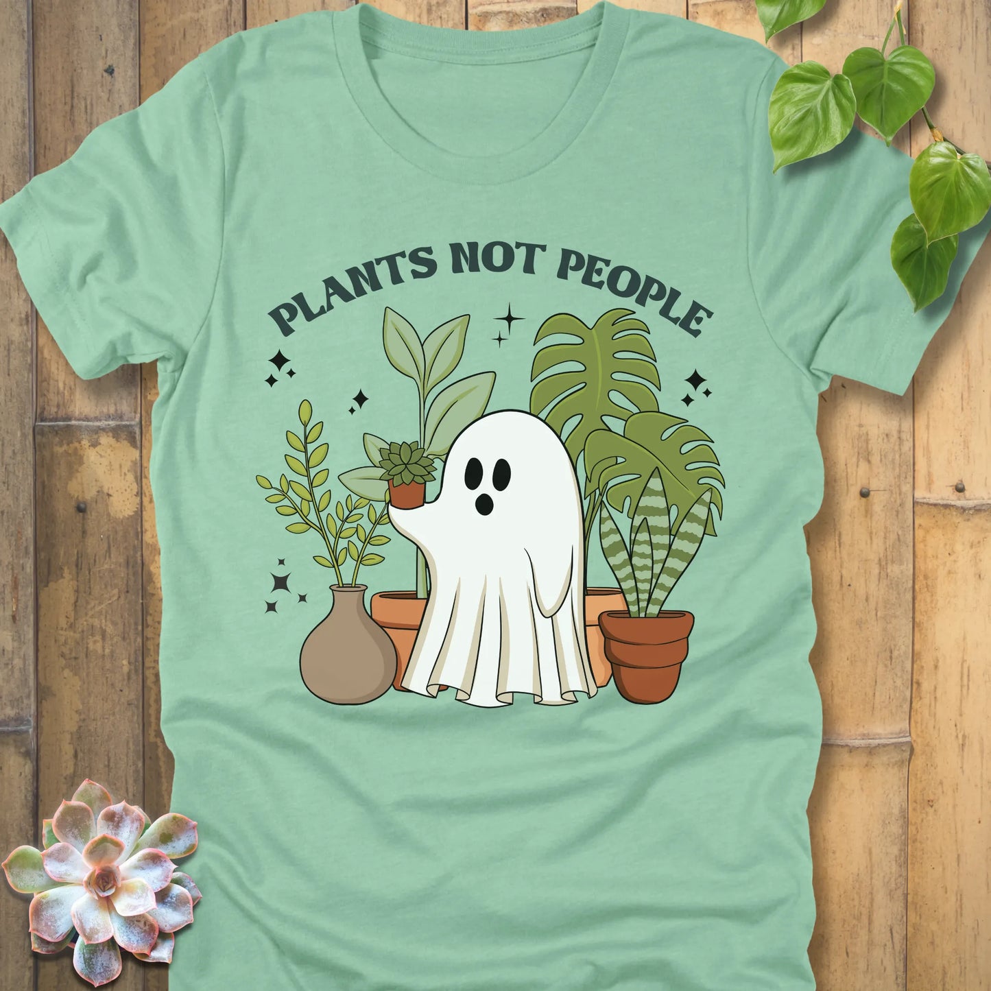 Heather Mint t-shirt featuring the design Plants Not People printed in bold letters with halloween design a ghost holding plants