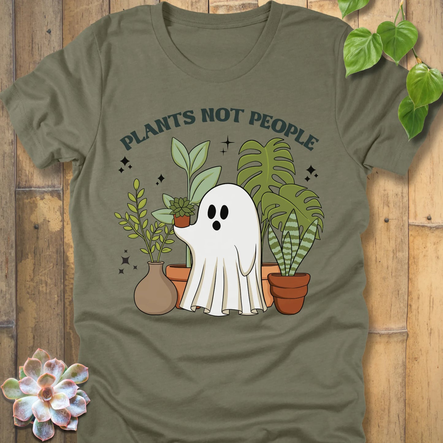 Heather Olive t-shirt featuring the design Plants Not People printed in bold letters with halloween design a ghost holding plants