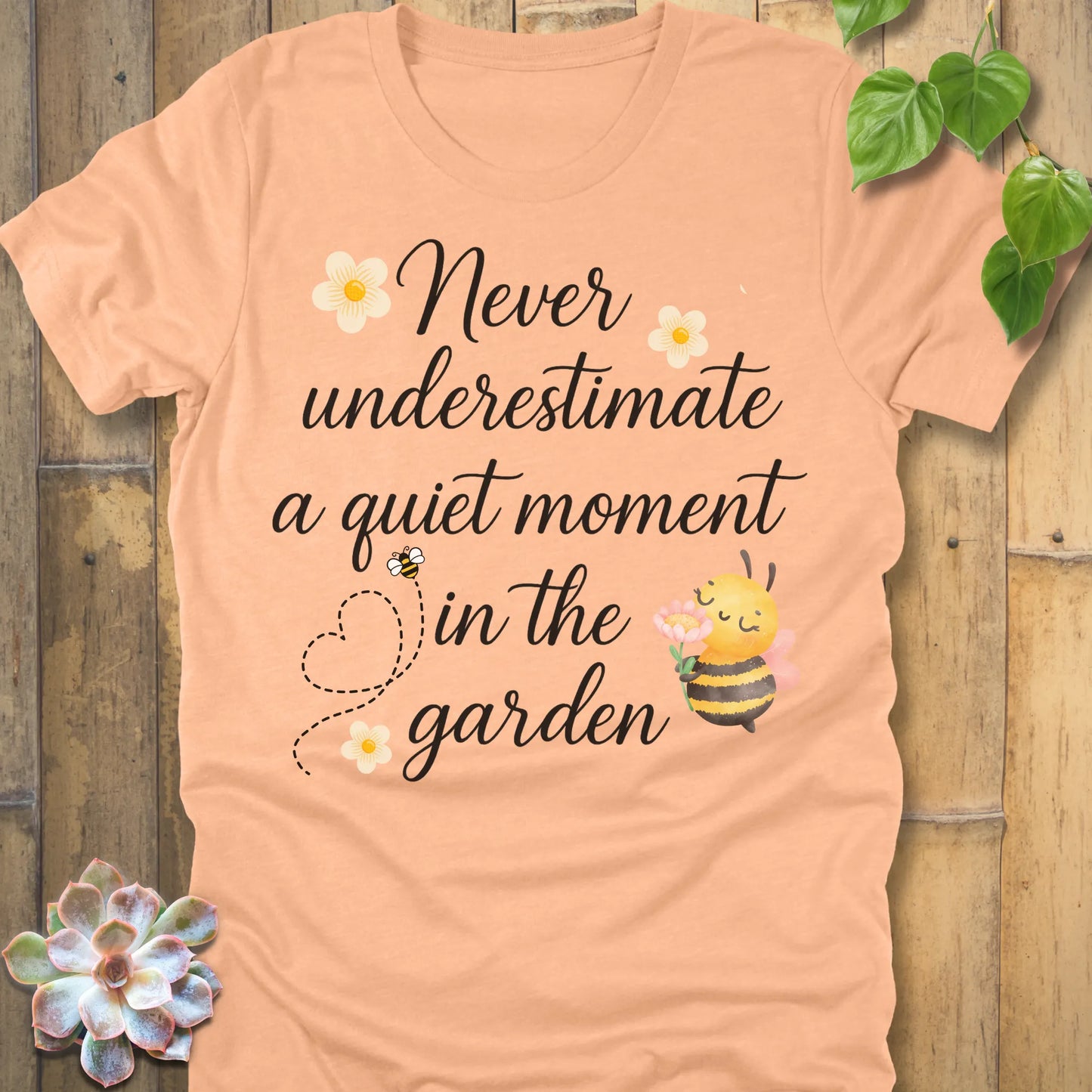 Heather Peach t-shirt featuring the design Never Underestimate printed in black letters, empowering quote shirt.