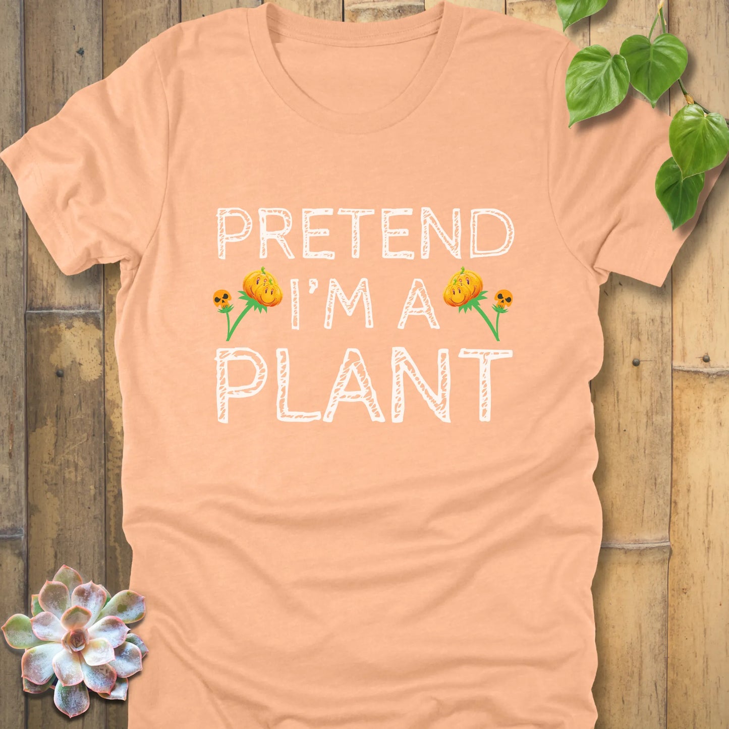 Heather Peach t-shirt featuring the design Pretend I'm A Plant printed in white letters with plants