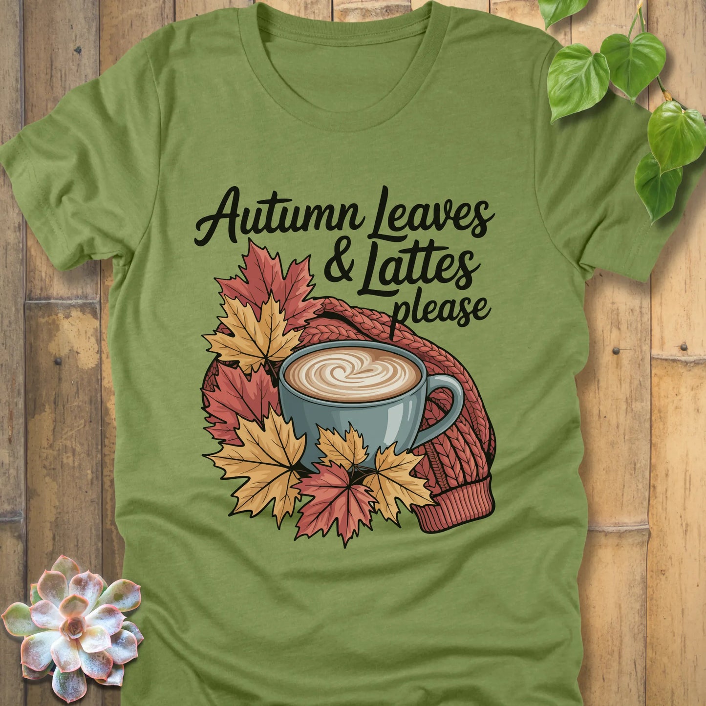 Heather green t-shirt featuring the design Autumn Leaves & Lattes printed in black letters with a mug of coffee and leaves