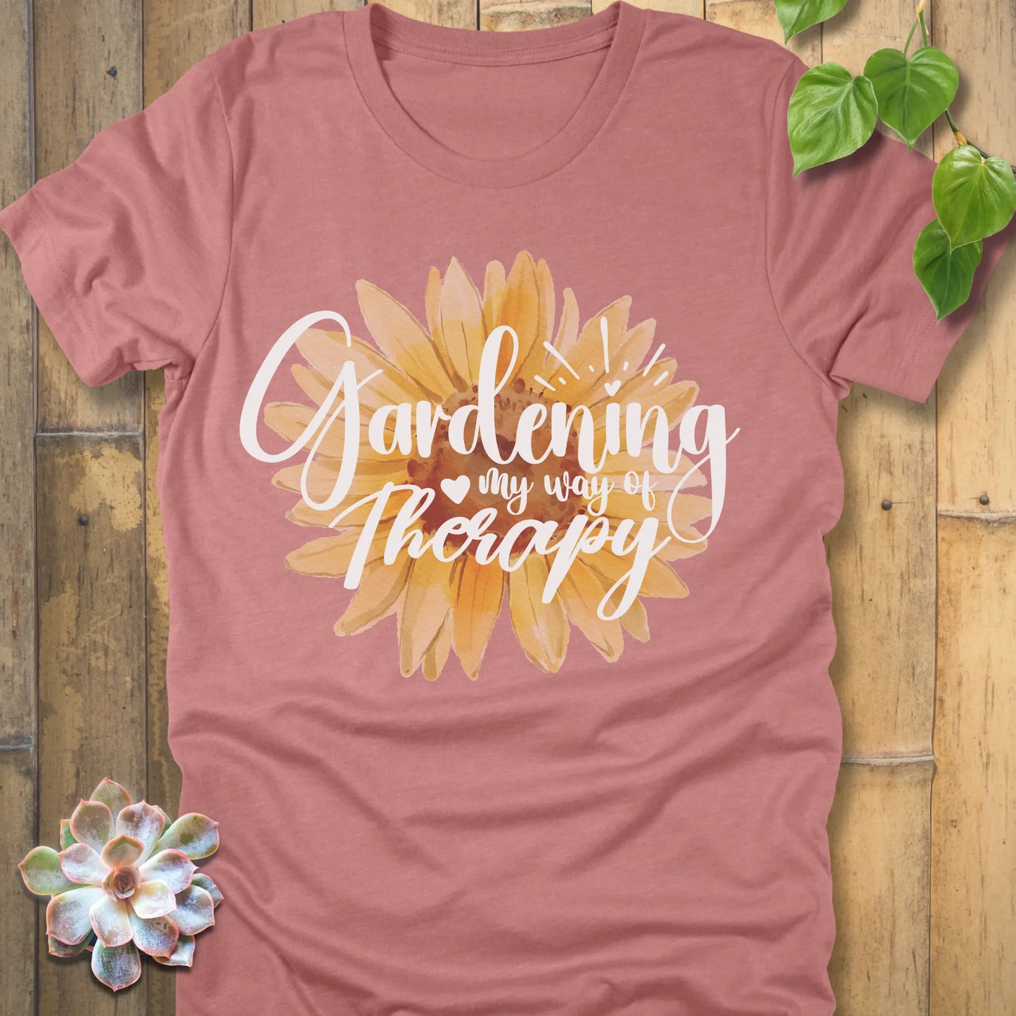 Heather mauve t-shirt featuring the design Gardening my way of therapy with a sunflower in the center.