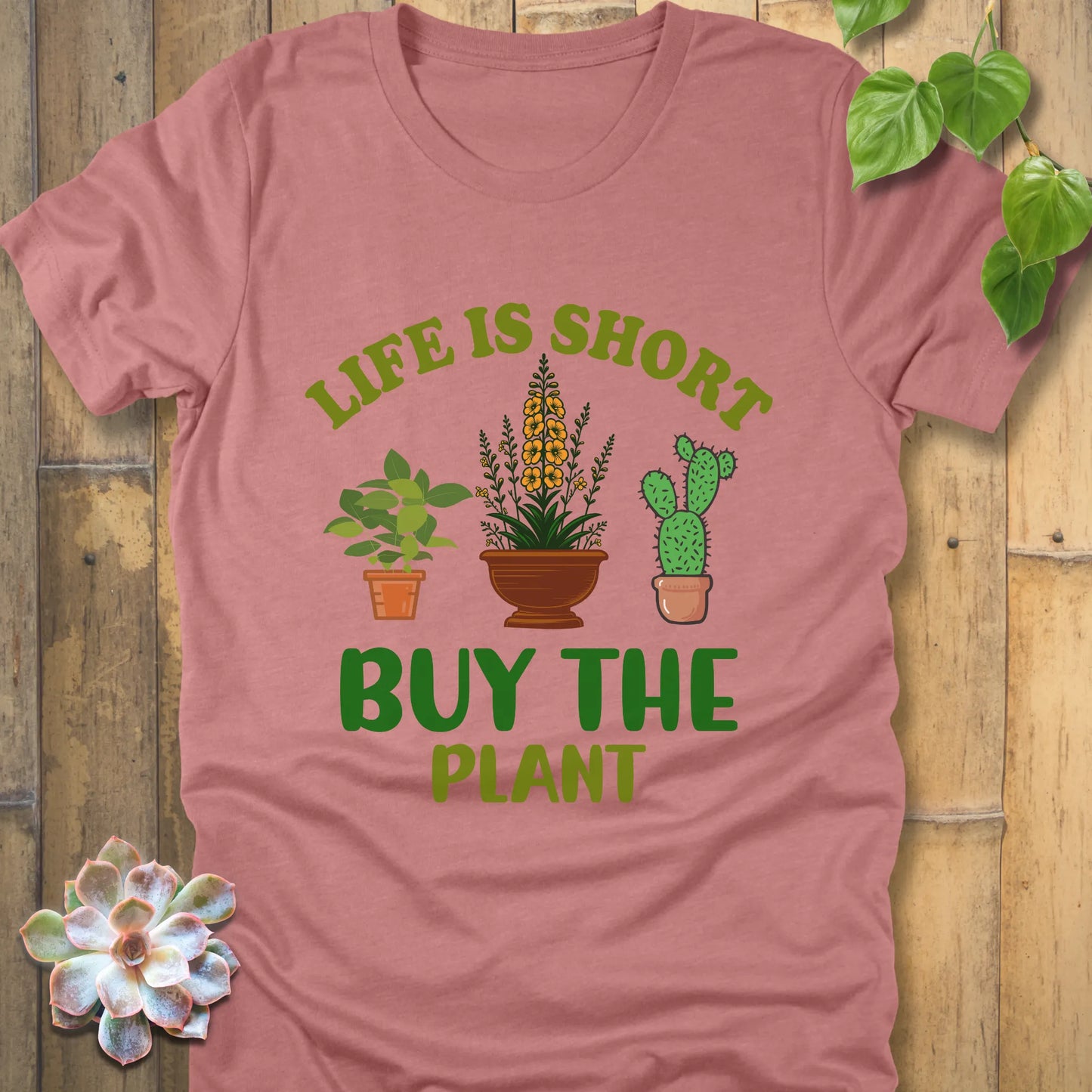 Heather mauve t-shirt featuring the design Life is short, buy the plant printed in green text with plant illustration