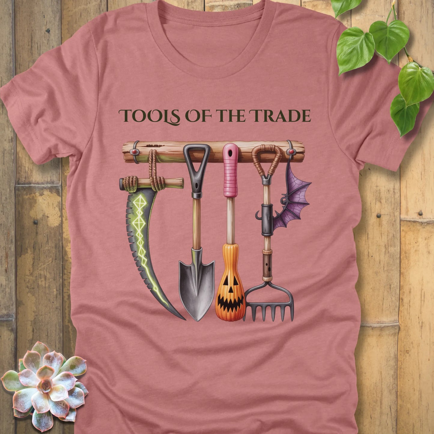 Heather mauve t-shirt featuring the design Tools of the Trade printed in bold letters with a halloween tools
