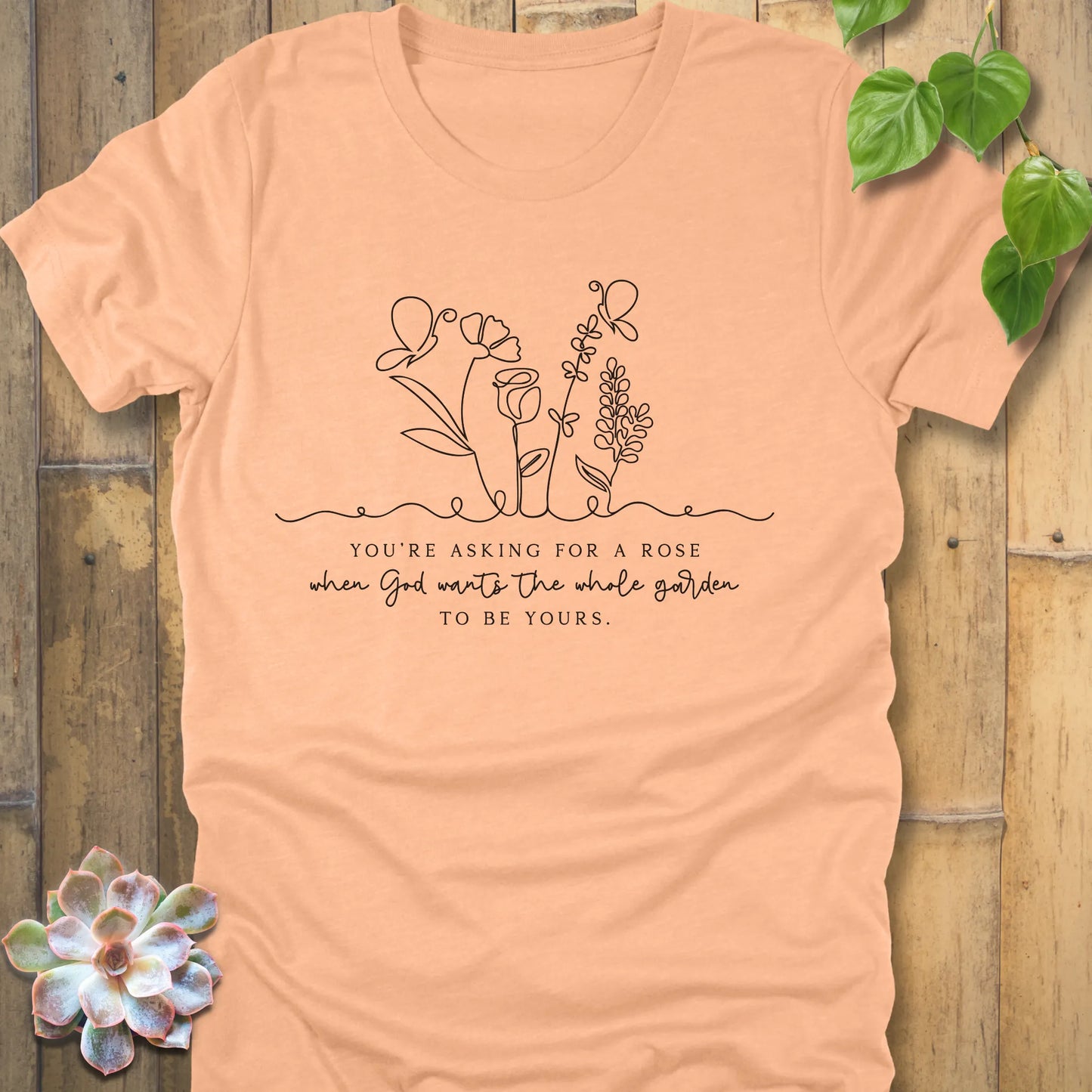 Heather peach t-shirt featuring the design Asking for a rose, printed in black letters, soft pastel cotton shirt