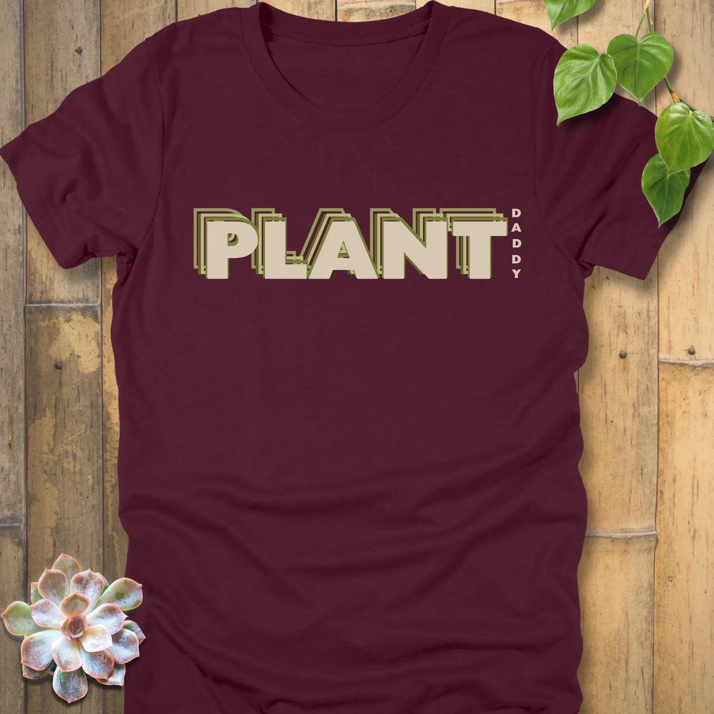 Maroon t-shirt featuring the design Plant Daddy printed in bold letters, soft cotton botanical shirt.