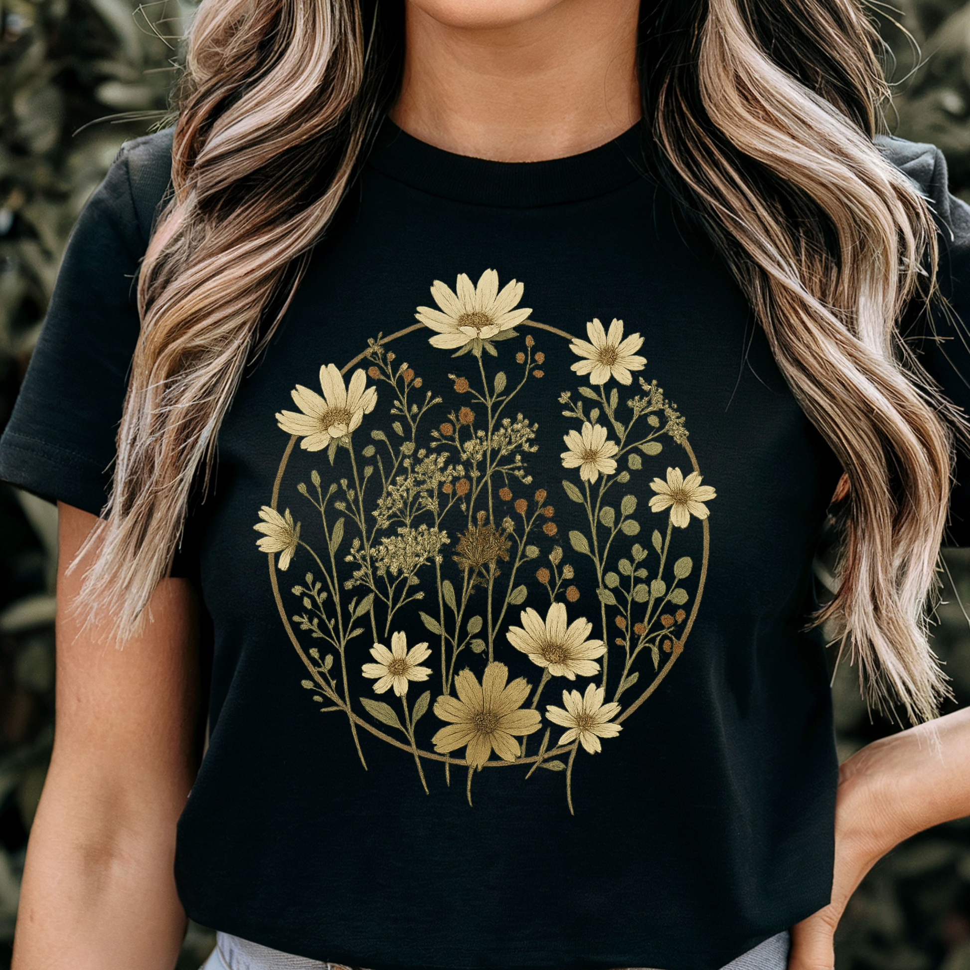 Woman wearing a Black heather t-shirt with vintage botanical circle design of daisies and meadow wildflowers, rustic floral graphic tee