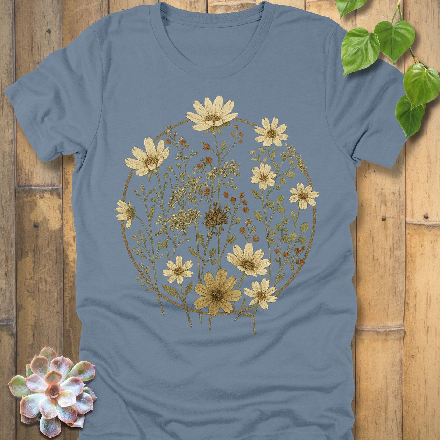 Steel blue vintage floral graphic tee with hand-drawn daisies and meadow wildflowers inside a rustic botanical circle.