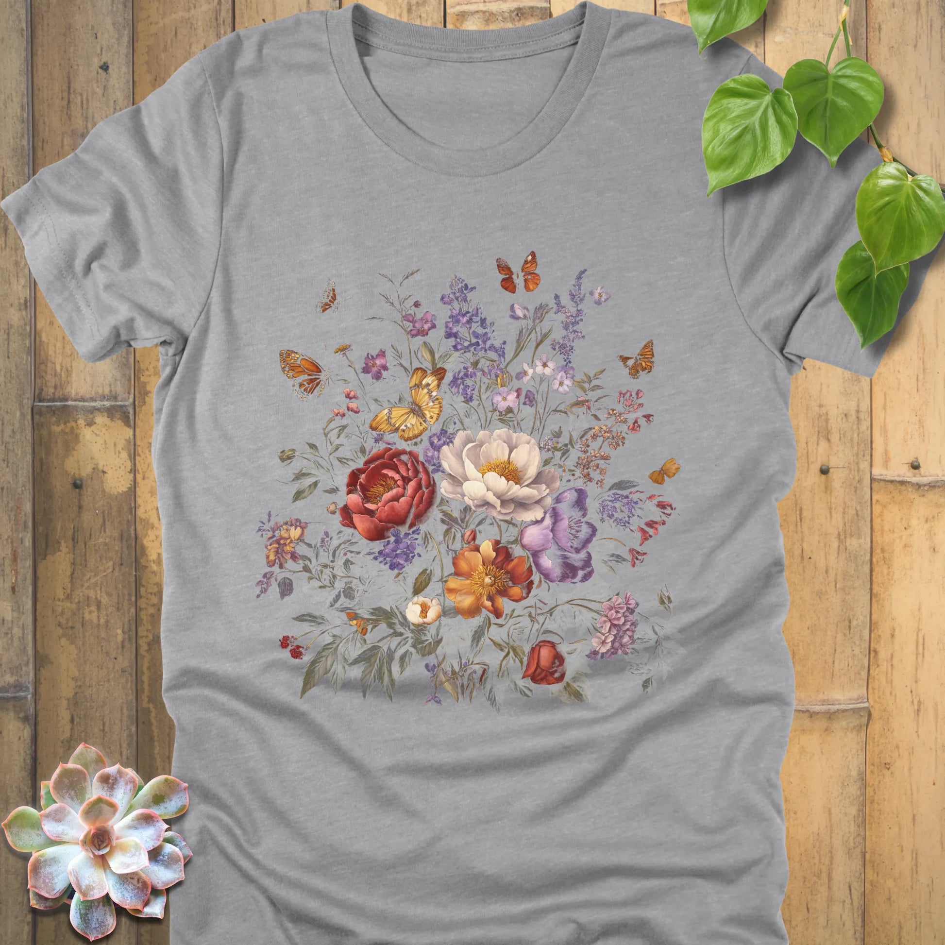 Athletic Heather t-shirt featuring a striking floral bouquet in red, white, orange, and purple tones with butterflies above