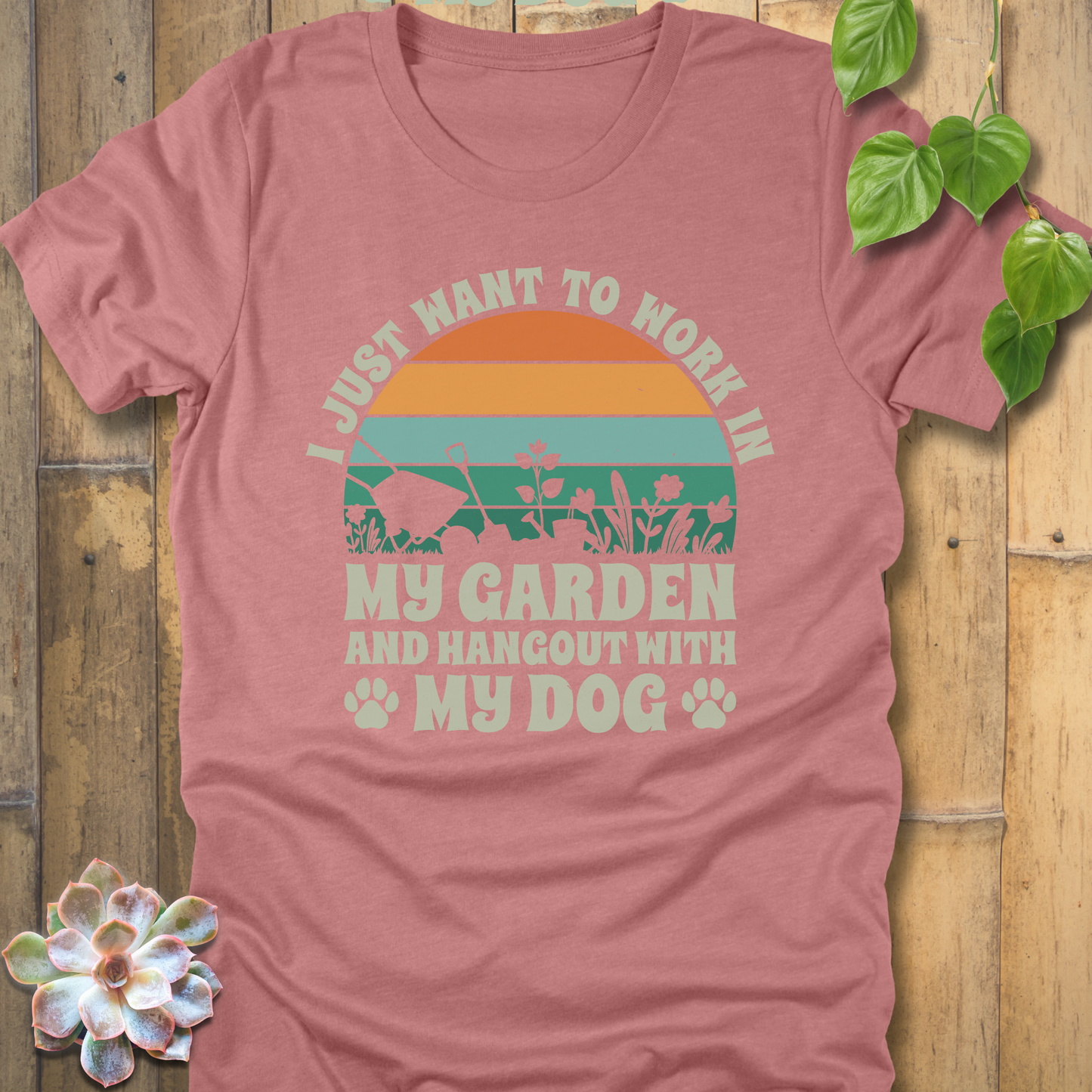 Heather Mauve t-shirt with a retro stripe sunset design, garden tools, and slogan text I just want to work in my garden and hang out with my dog, with paw prints at the bottom