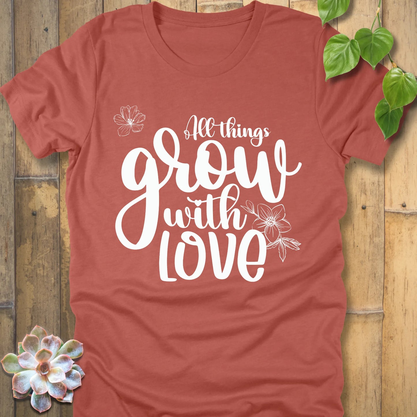 Heather clay unisex T-shirt featuring the inspirational quote ‘All things grow with love’ in bold white script with floral line art.