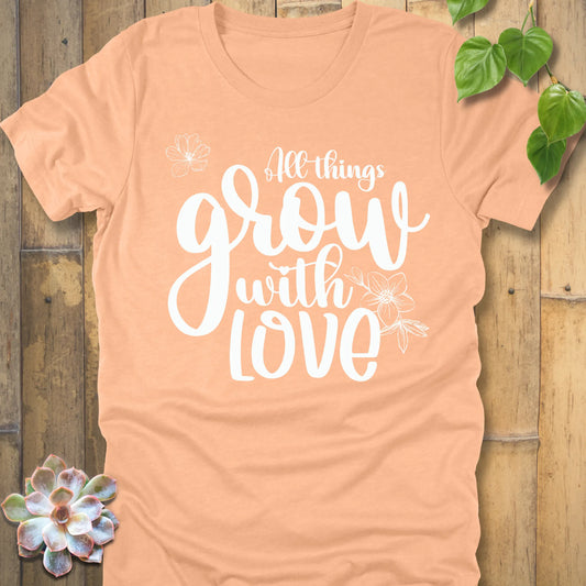 Heather peach unisex T-shirt featuring the inspirational quote ‘All things grow with love’ in bold white script with floral line art