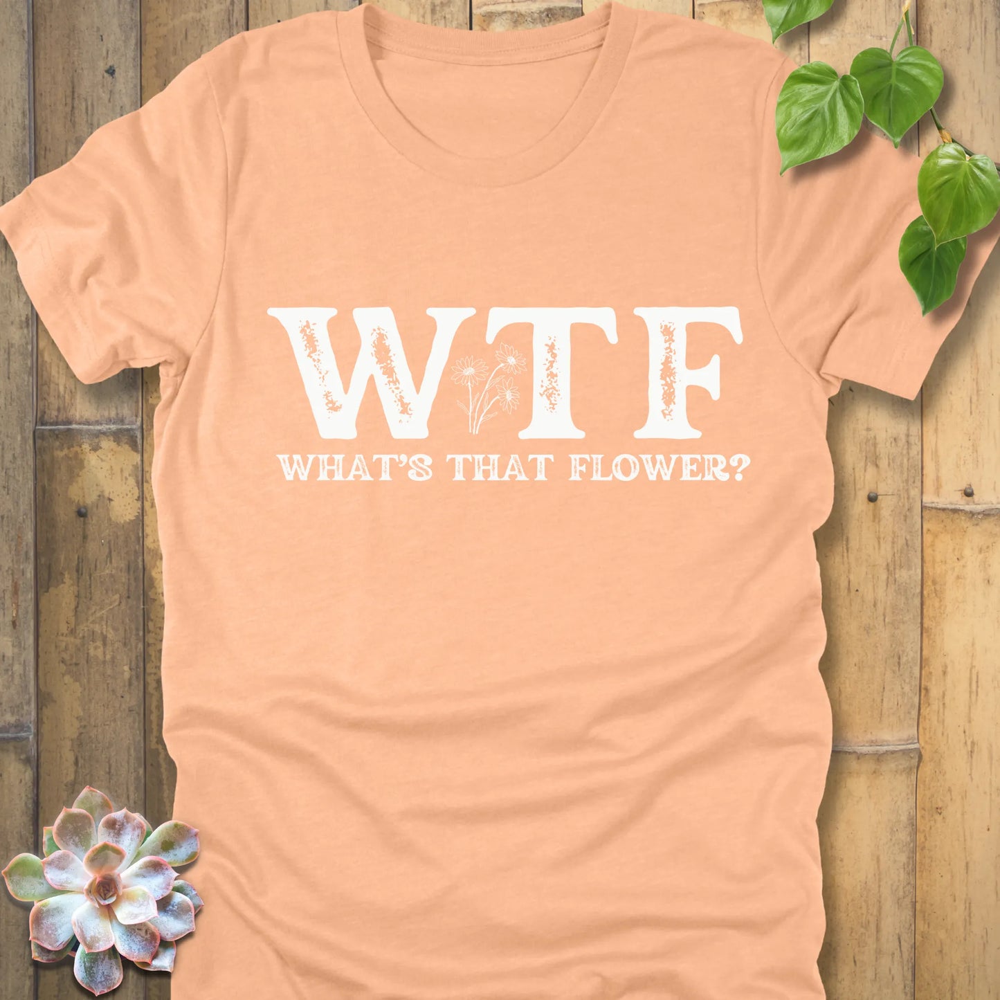 Heather Peach novelty graphic shirt featuring WTF in bold letters, What’s That Flower text, and flower artwork