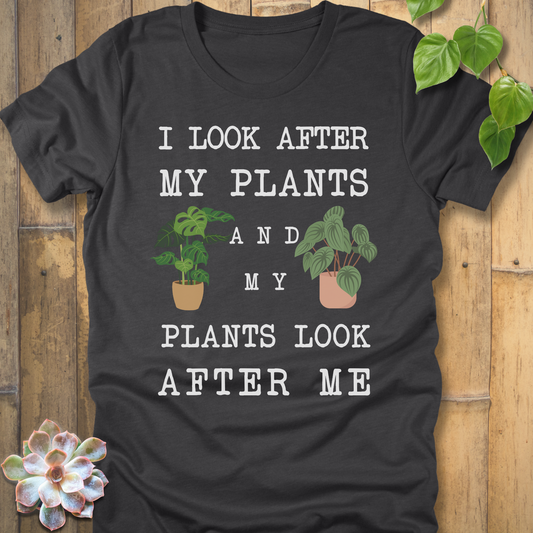 Dark Grey Heather t-shirt with white writing saying I look after my plants and my plants look after me. I have two house plants on each side. 