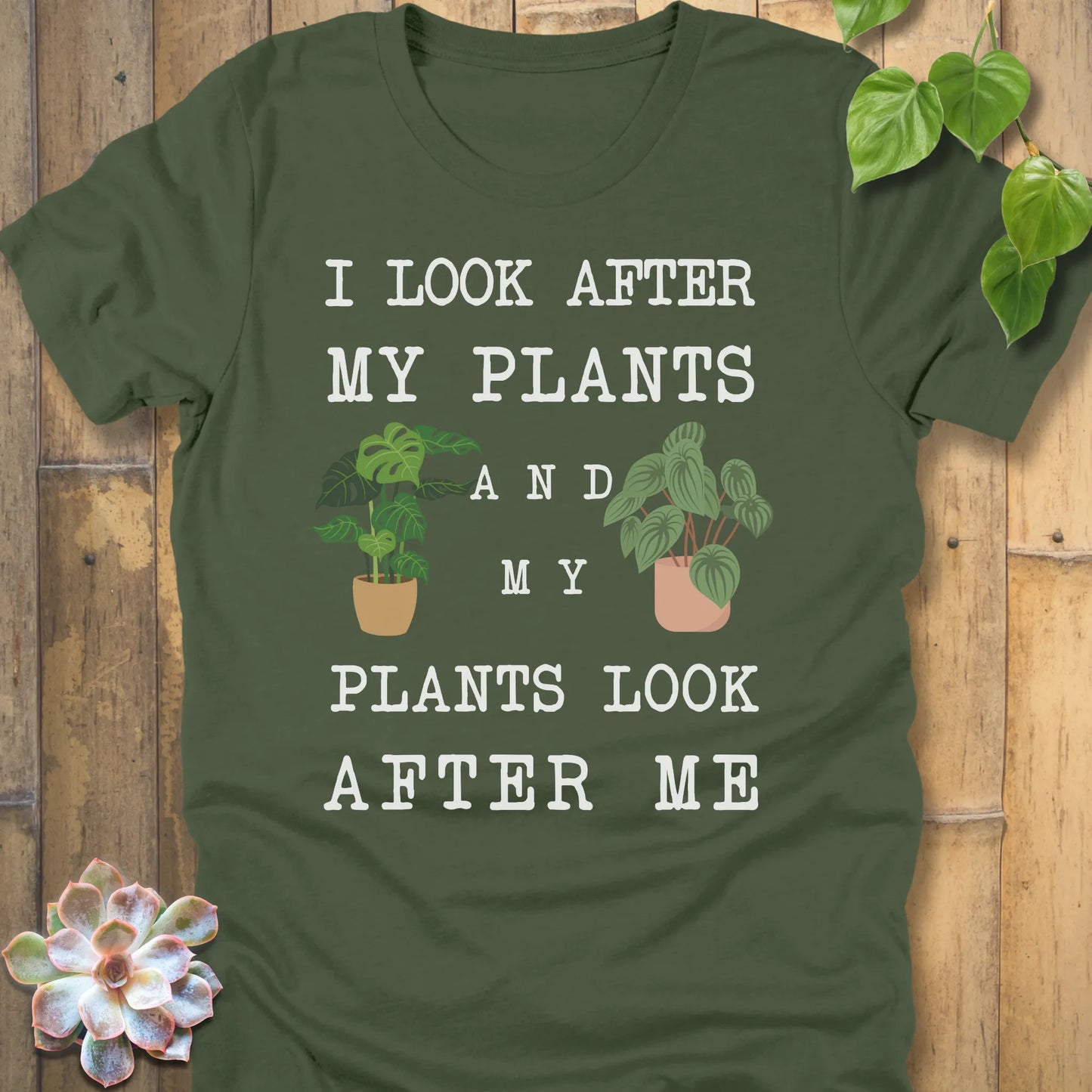 Military Green Bella Canvas 3001  t-shirt with white writing saying I look after my plants and my plants look after me. I have two house plants on each side. 