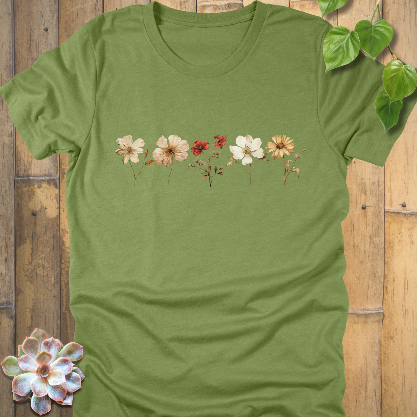 Heather Green t-shirt featuring a row of dried wildflowers in soft cream, orange, and red tones printed across the front