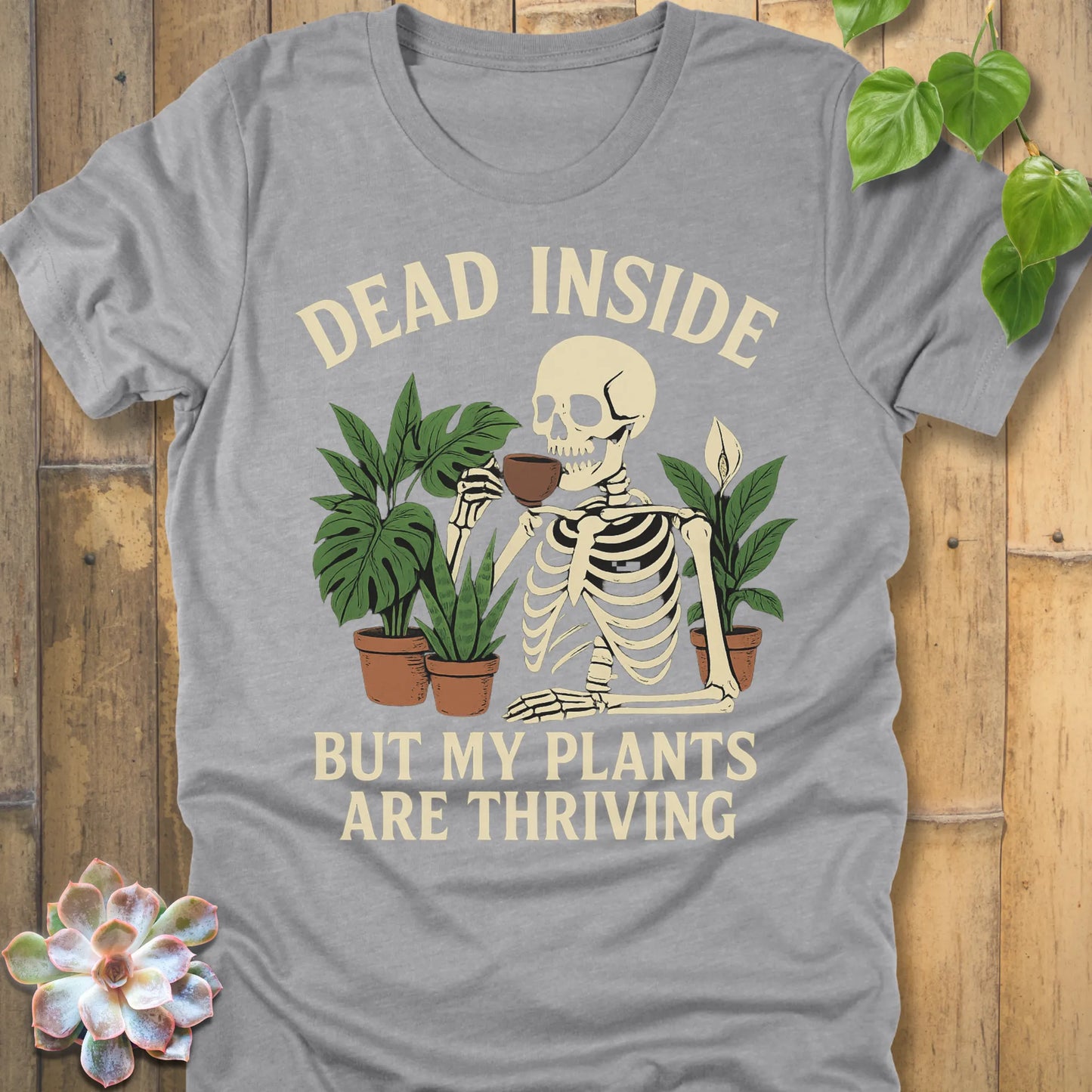 Athletic Heather t-shirt featuring the design Dead Inside printed in bold letters and plants, skeleton, funny graphic tee.