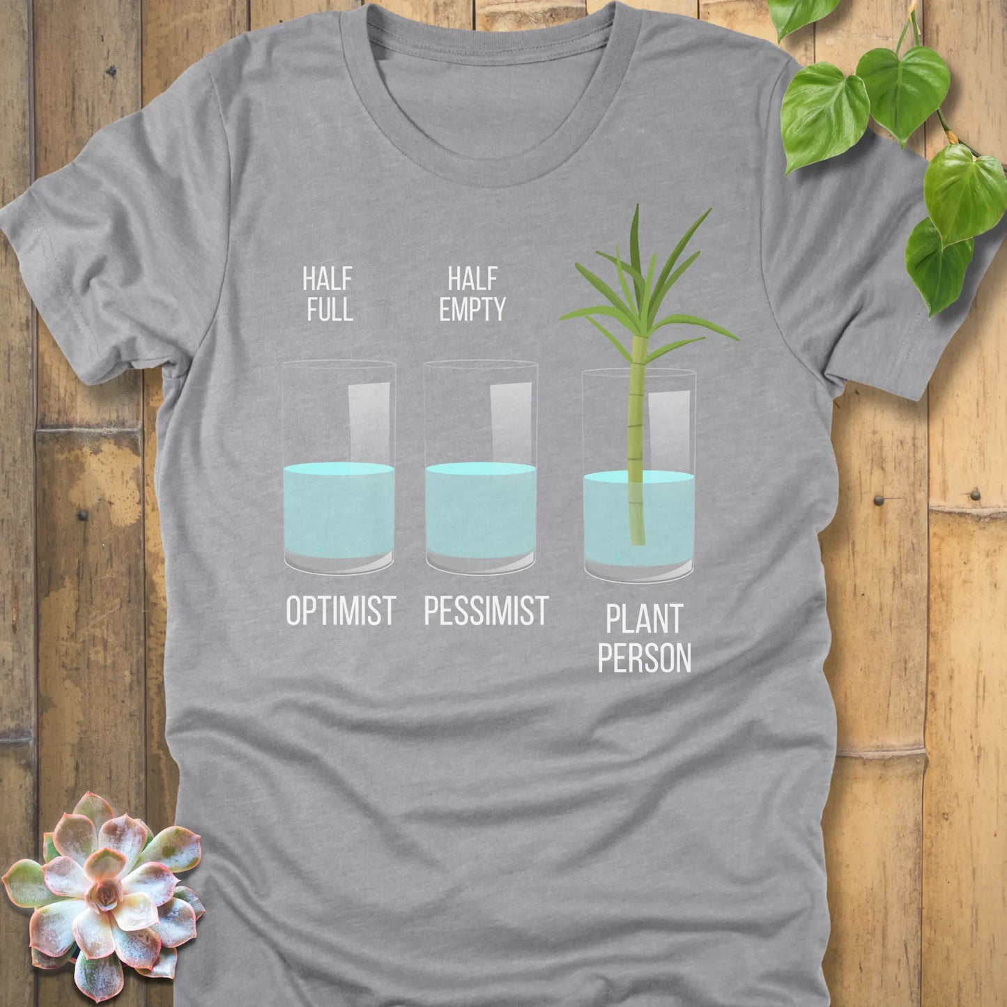 Athletic Heather t-shirt featuring the design Plant Person printed in bold letters printed in glass of water, and a plant