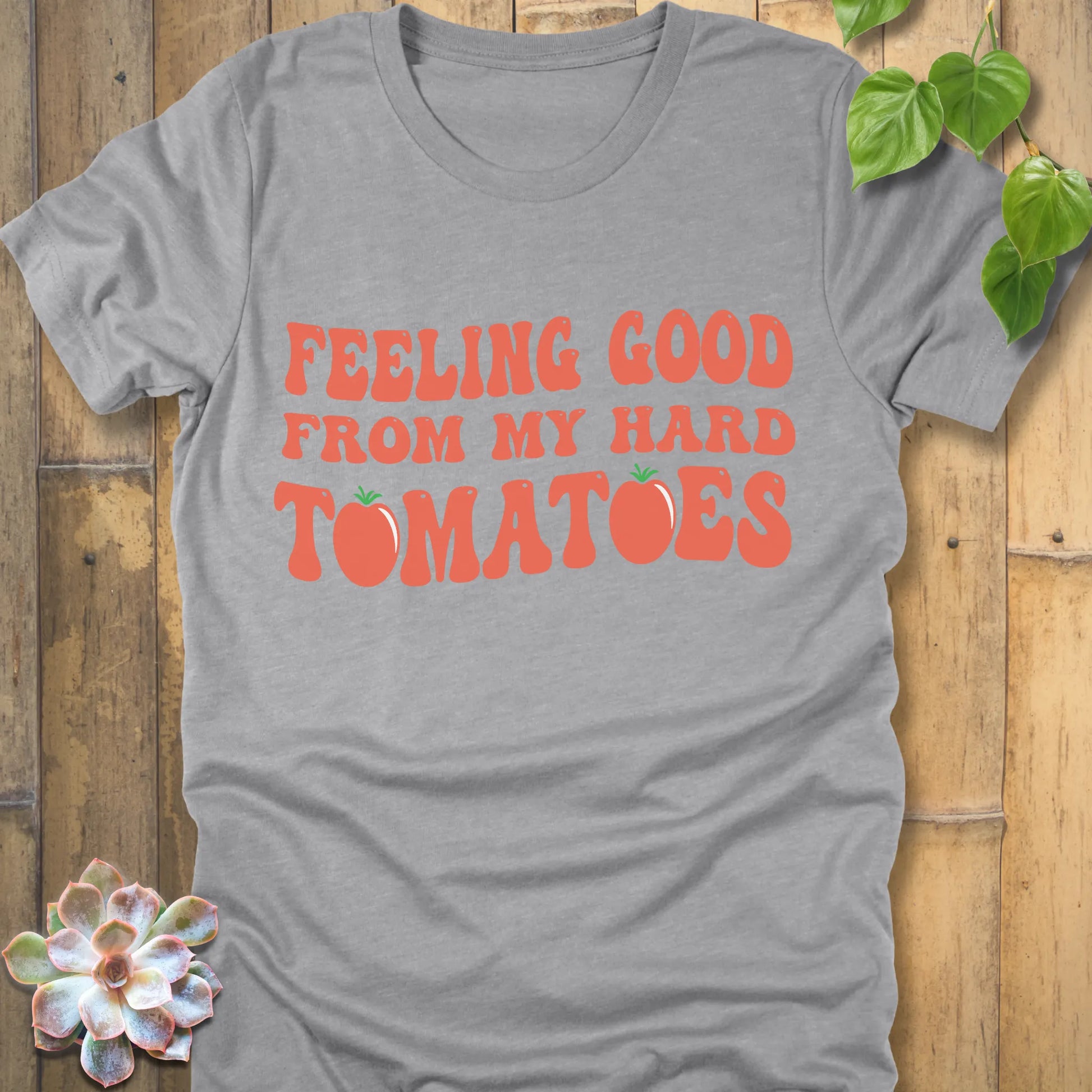 Athletic grey t-shirt featuring the design "Feeling Good from my hard tomatoes" printed in bold orange letters