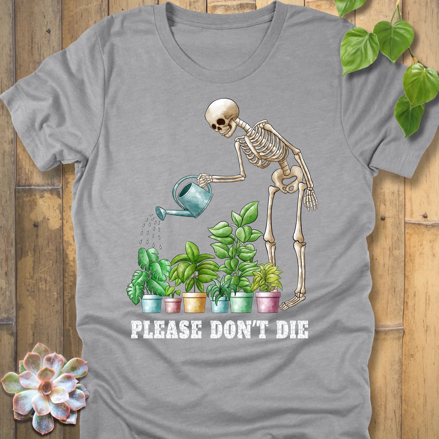 Athletic grey t-shirt featuring the design Please Don’t Die with skeleton watering plants print