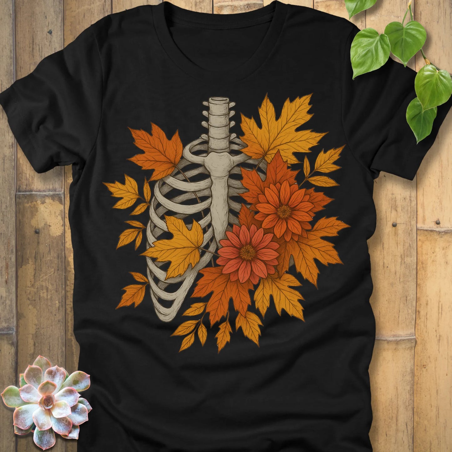 Black t-shirt featuring the design Autumn Bones printed Halloween skeleton shirt with flowers and leaves.