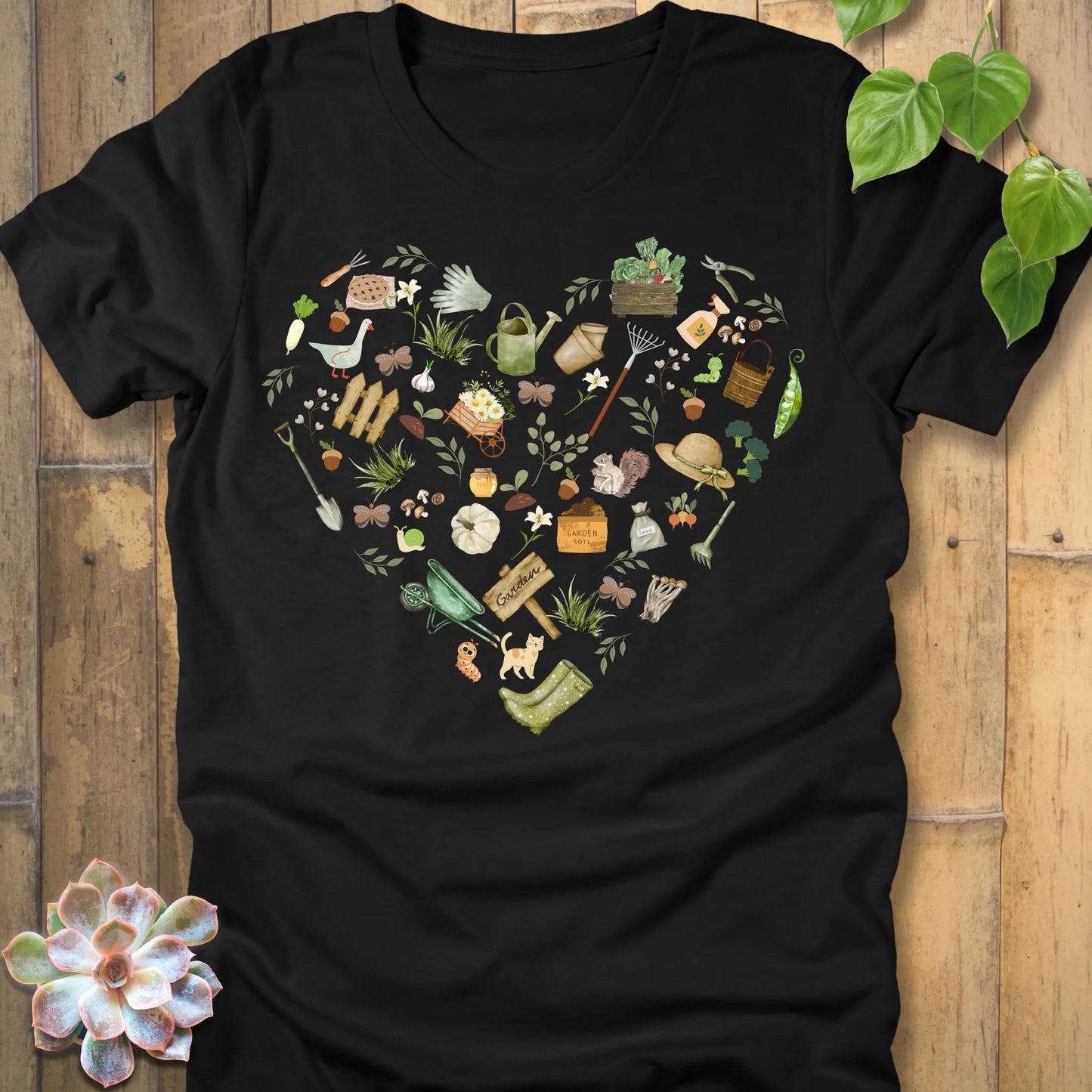 Black t-shirt featuring the design Gardening Loveheart printed in heart shape with tools, plant lover shirt.