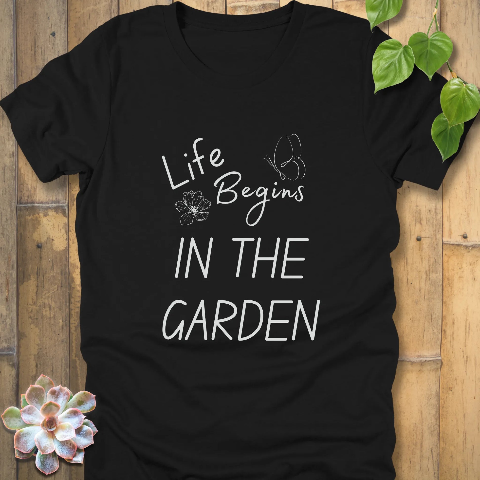 Black t-shirt featuring the design Life begin's in the garden, stylish plant lover t-shirt.