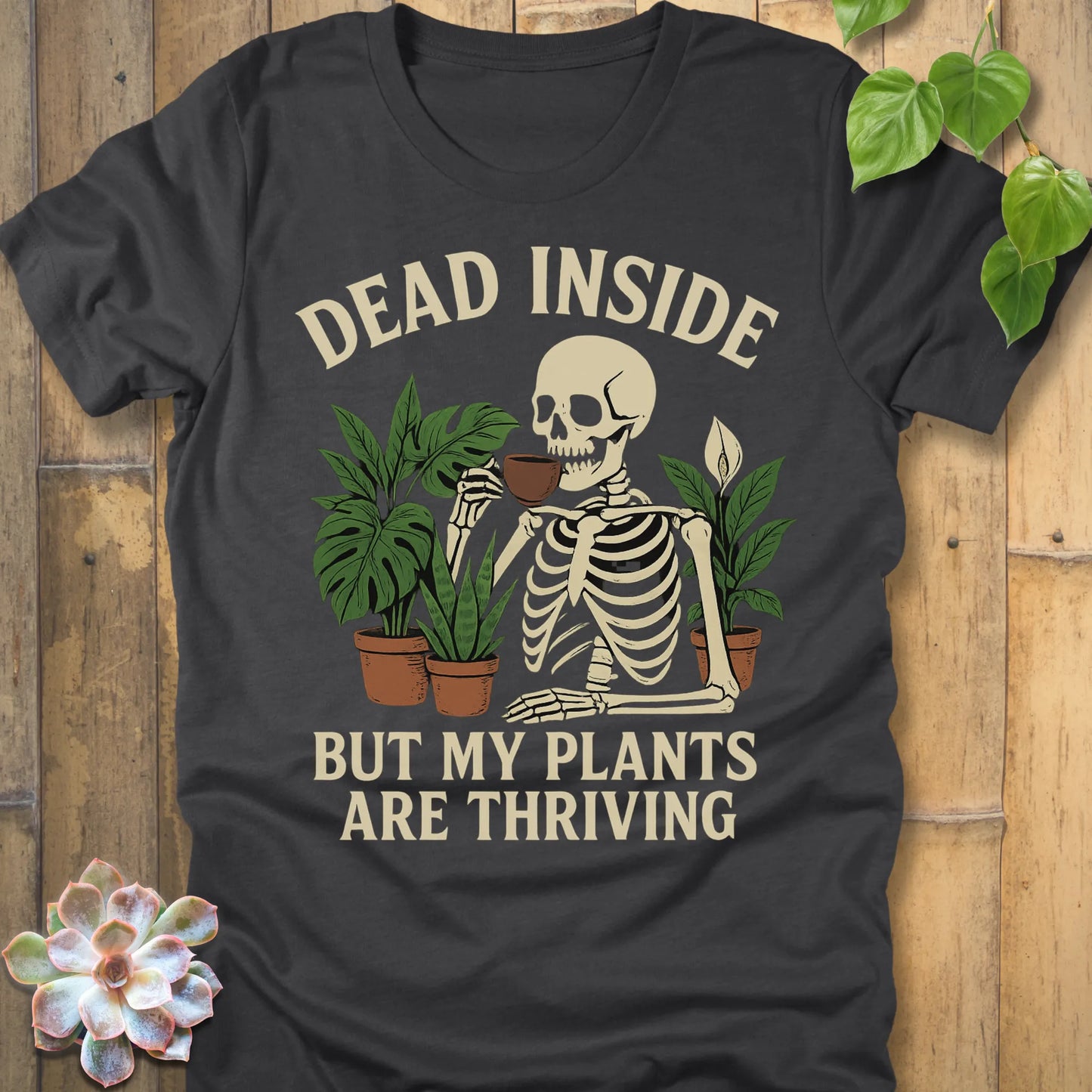 Dark Grey Heather t-shirt featuring the design Dead Inside printed in bold letters and plants, skeleton, funny graphic tee.