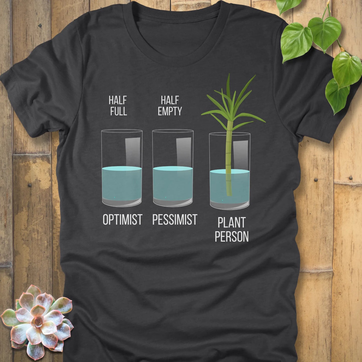 Dark Grey Heather t-shirt featuring the design Plant Person printed in bold letters printed in glass of water, and a plant
