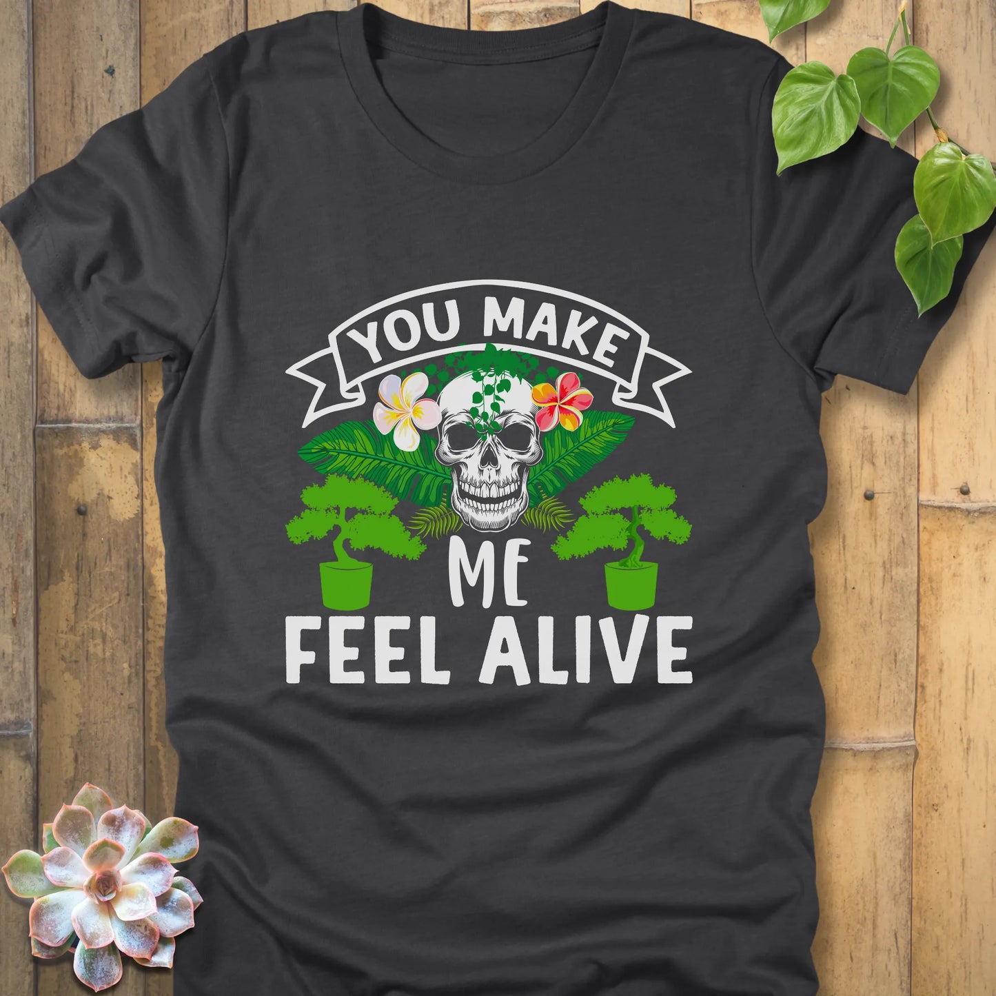 Dark Grey Heather t-shirt featuring the design You Make Me Feel Alive printed in bold white letters with skull and plants