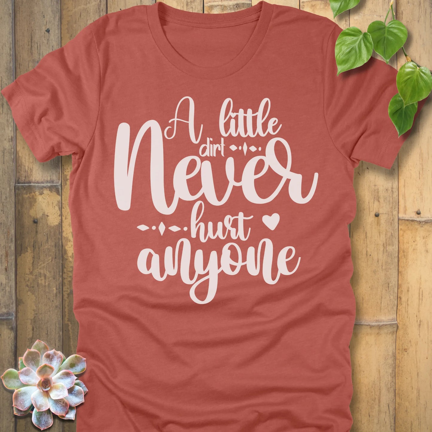 Heather Clay gardening t-shirt featuring the design A Little Dirt printed in white letters